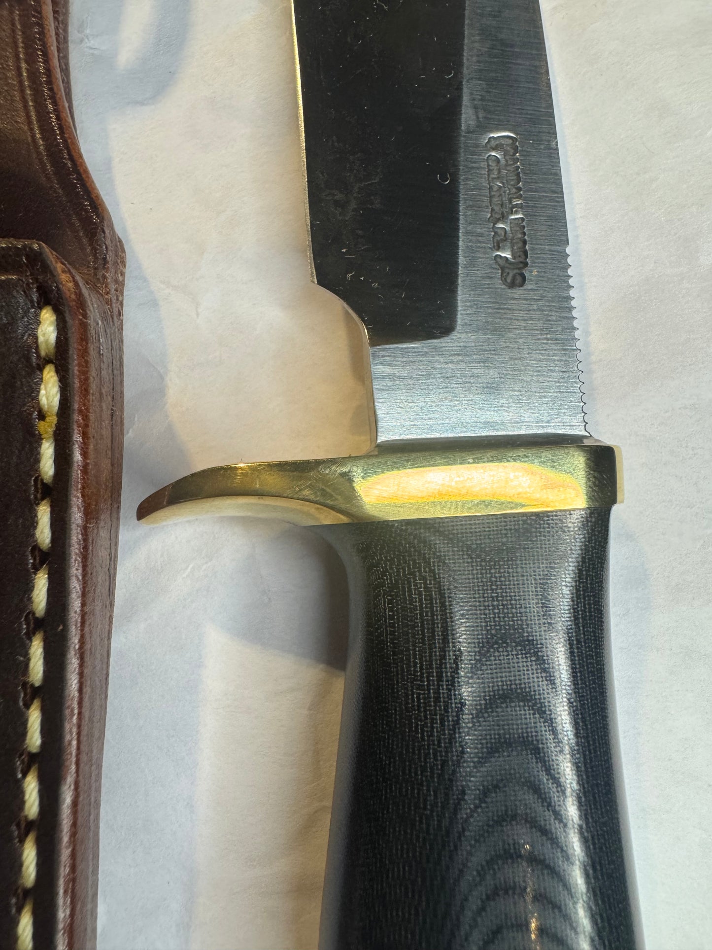 New in Paper Randall Model 28 Woodsman in Black Micarta. SS blade, brass single hilt. Lanyard. Brown leather sheath.