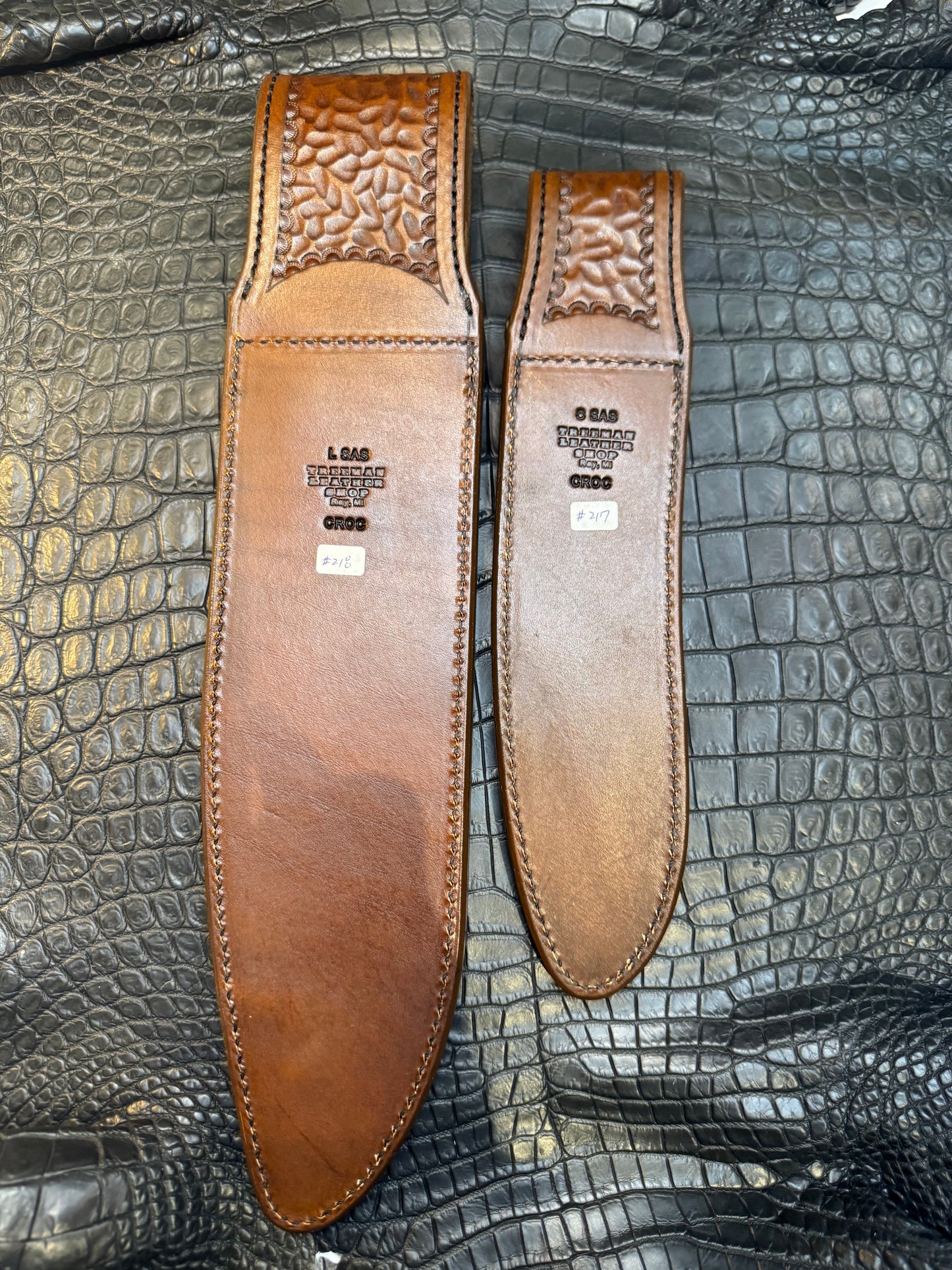 A pair of Randall Model 12-11 Large Sasquatch and Randall Model 12-8 Small Sasquatch Sheaths in Exotic Antique Brown Crocodile by Treeman.