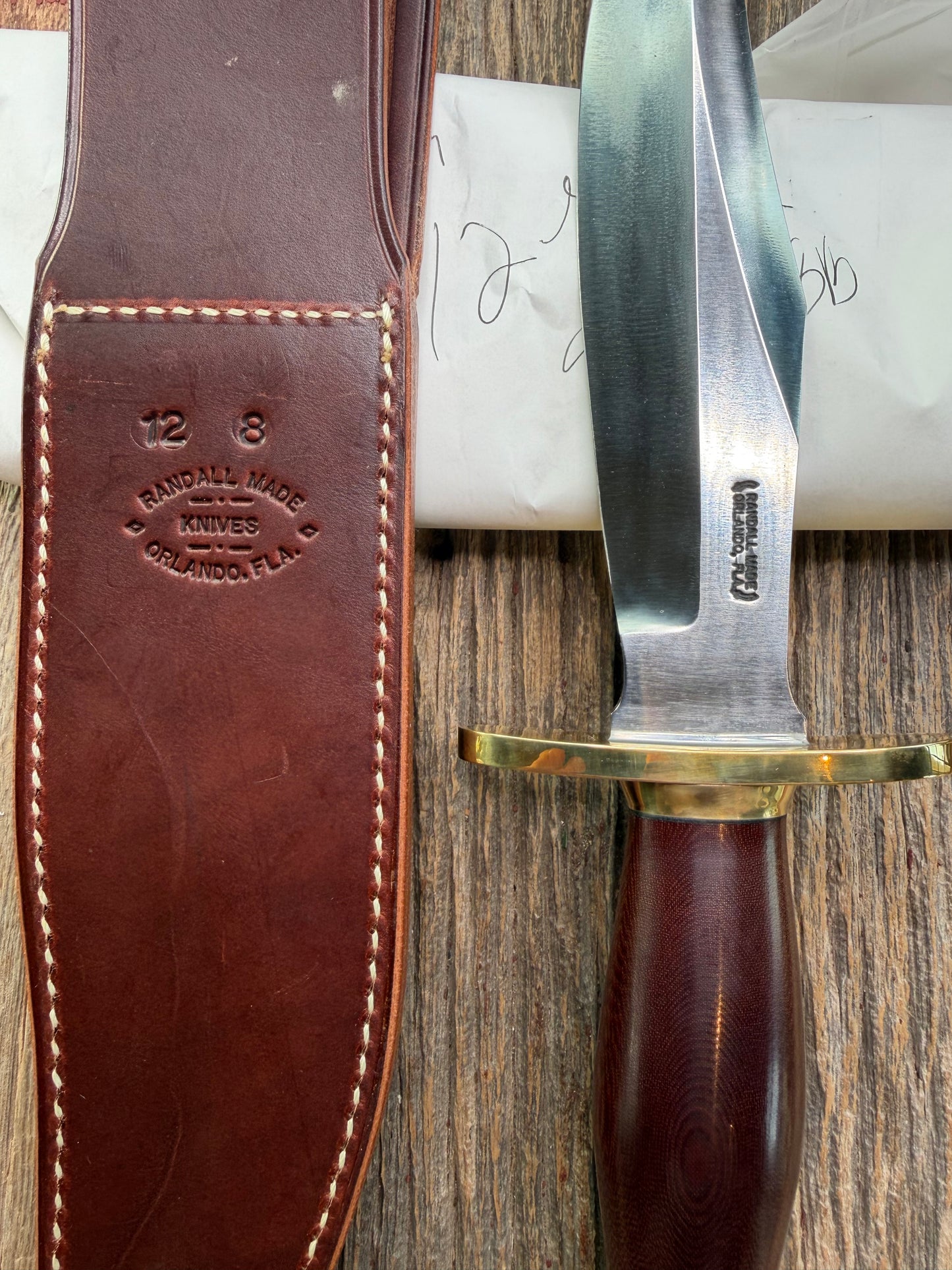 New in Paper Randall Model 12-8 Big Bear with a Maroon Micarta handle. Brass Hilt and Brass collar, Carbon steel, brass butt cap.