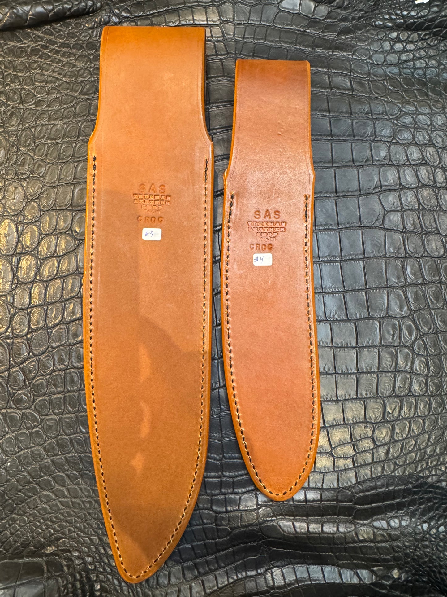 A pair of Randall Model 12-11 Large Sasquatch and Randall Model 12-8 Small Sasquatch Sheaths in Exotic Ivory Crocodile by Treeman.