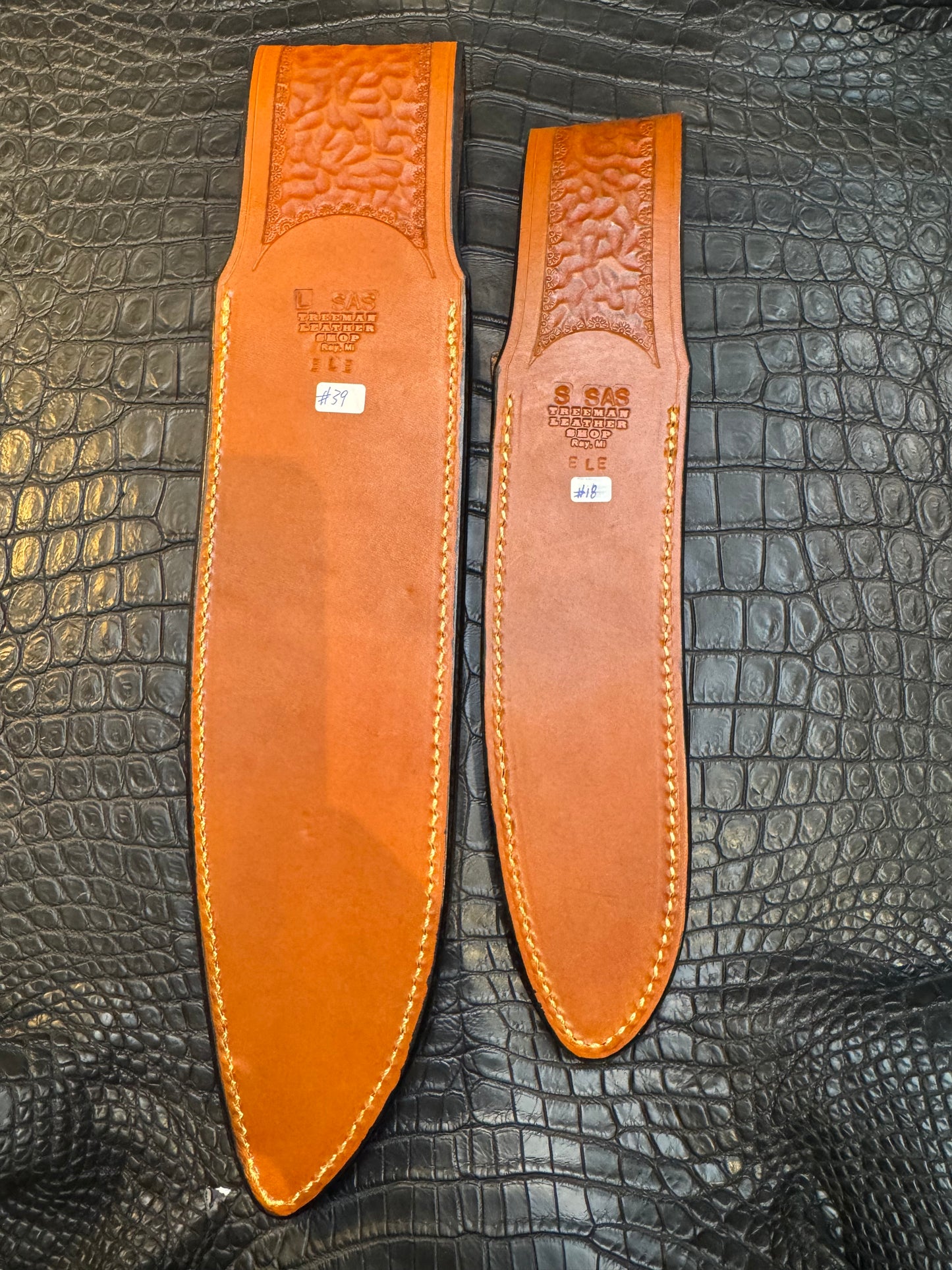 A pair of Randall Model 12-11 Large Sasquatch and Randall Model 12-8 Small Sasquatch Sheaths in Exotic Cognac Elephant by Treeman.