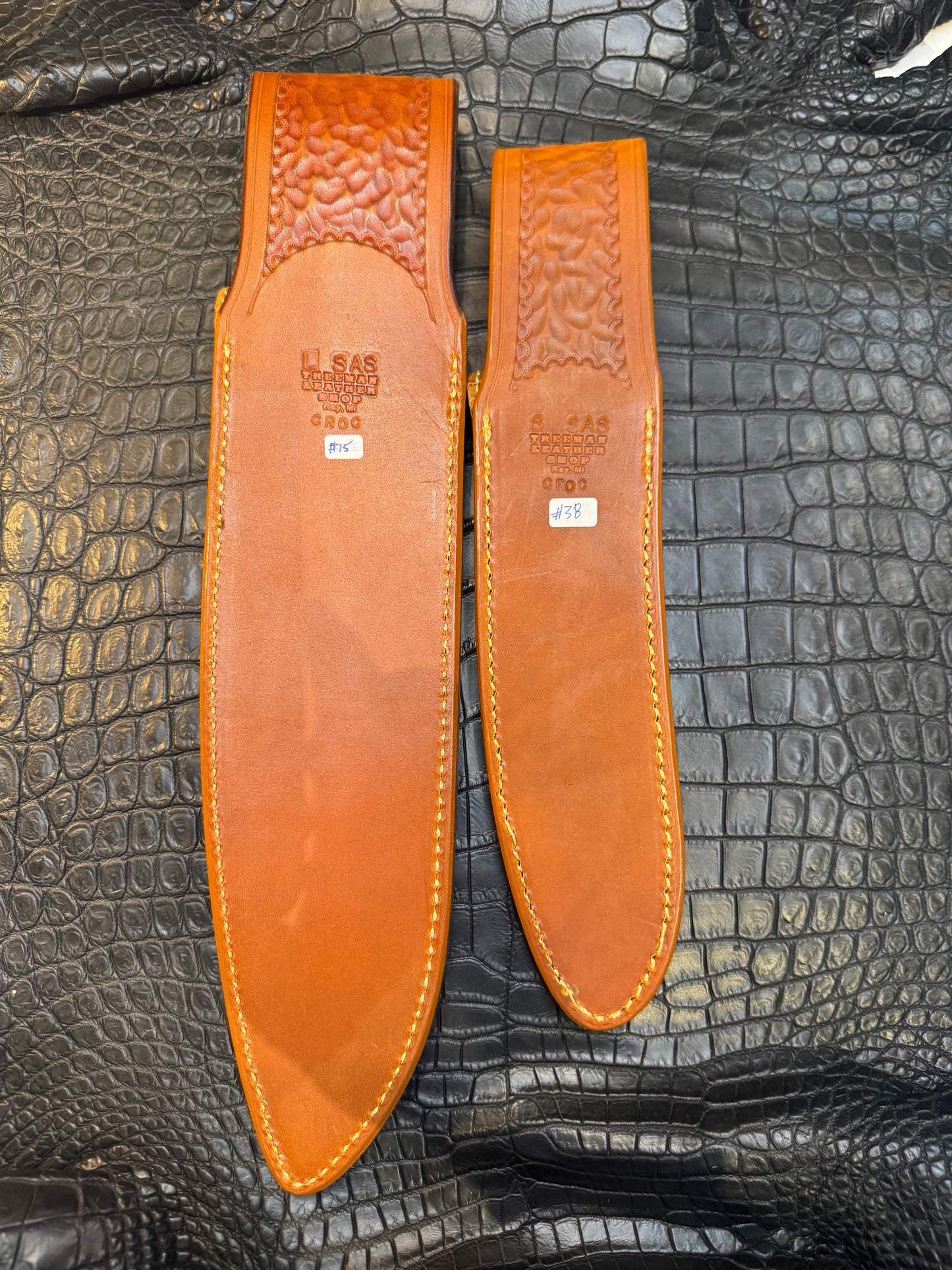 A pair of Randall Model 12-11 Large Sasquatch (Tail) and Randall Model 12-8 Small Sasquatch (Skull) Sheaths in Exotic Tan Hornback Crocodile by Treeman.