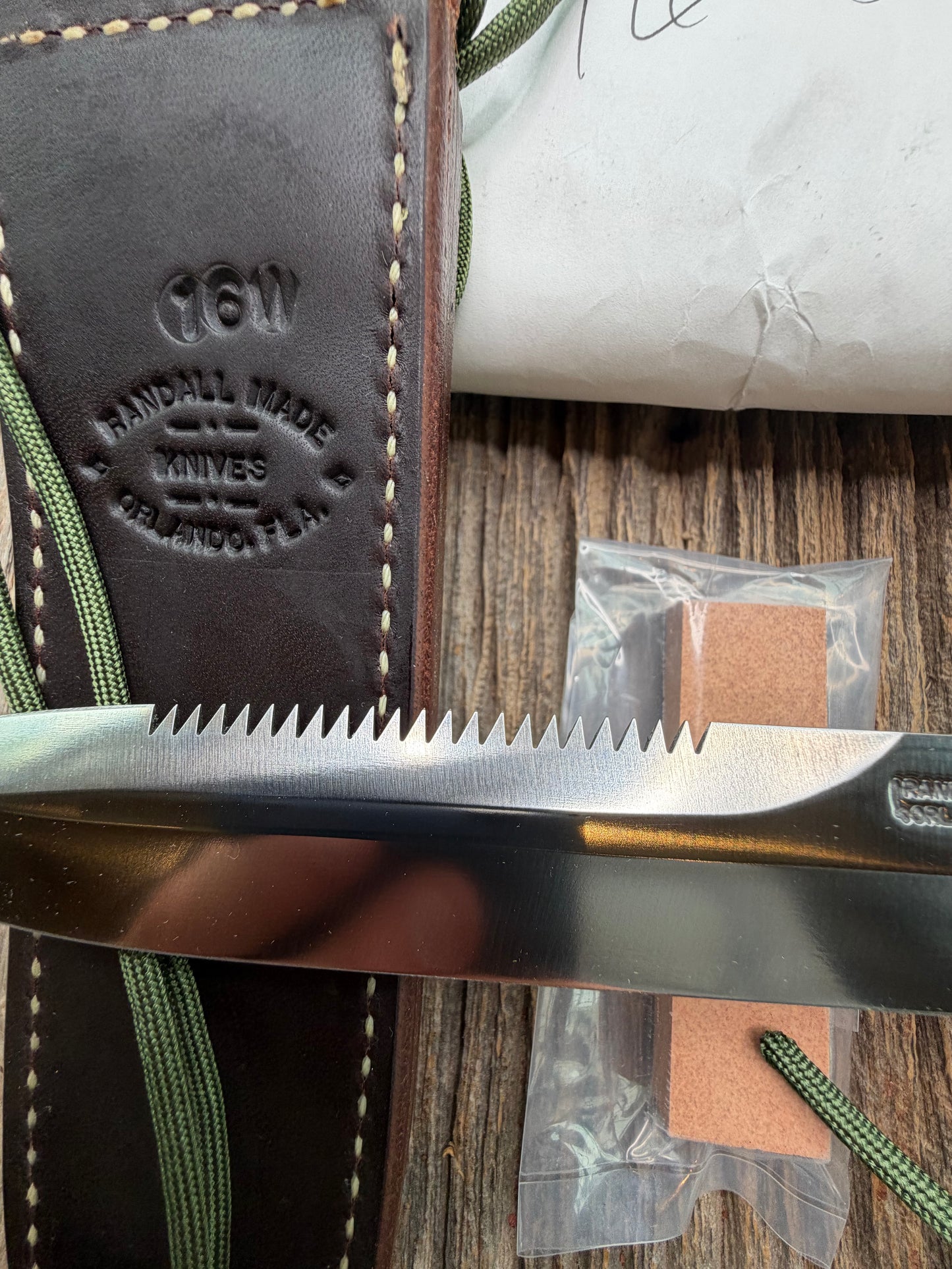New in Paper Randall Model 16-7 Diver with a Black Micarta handle, Single finger grip , SS blade, Brass hilt, Sawteeth, Lanyard, Brown leather waxed sheath.