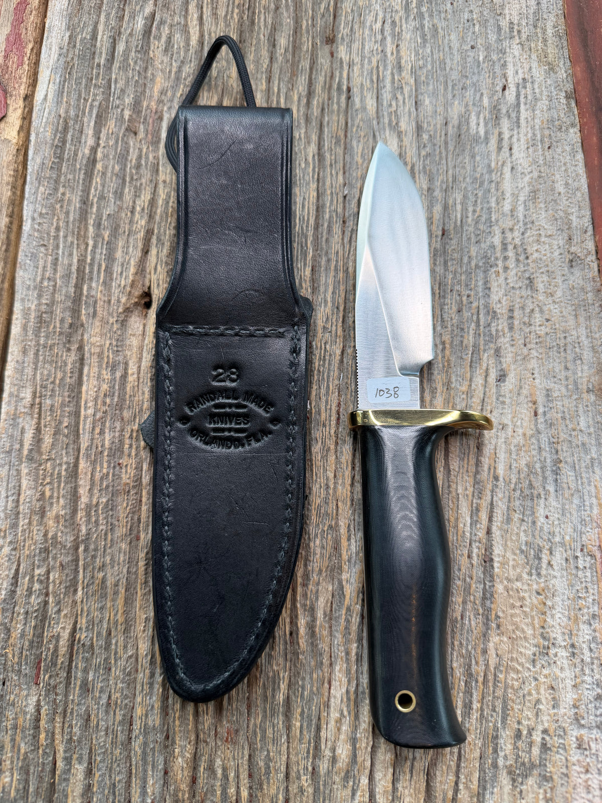 Nice Randall Model 28 Woodsman in Black Micarta. SS blade, brass single hilt. Lanyard hole. Black leather sheath.