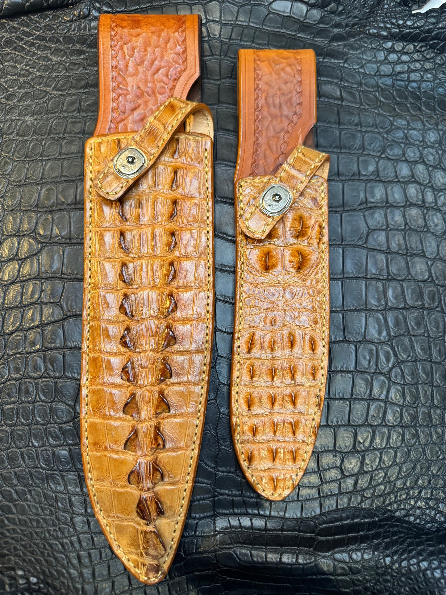 A pair of Randall Model 12-11 Large Sasquatch (Tail) and Randall Model 12-8 Small Sasquatch (Skull) Sheaths in Exotic Tan Hornback Crocodile by Treeman.
