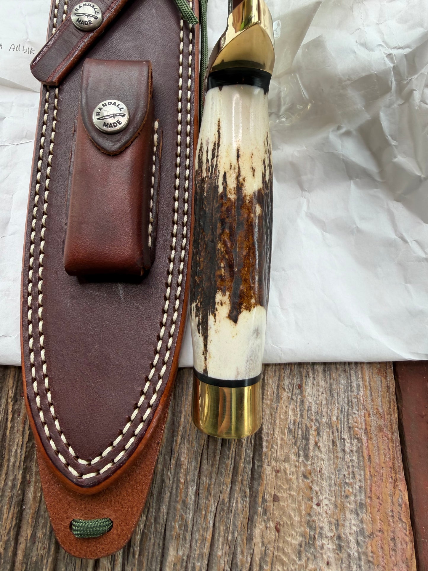 New in paper fresh from the Shop. Randall Knife Model 14-7.5 Big. Nice piece of Stag, Gorgeous Brass Lugged hilt and brass crows beak butt cap. Single black spacer. Stainless steel.