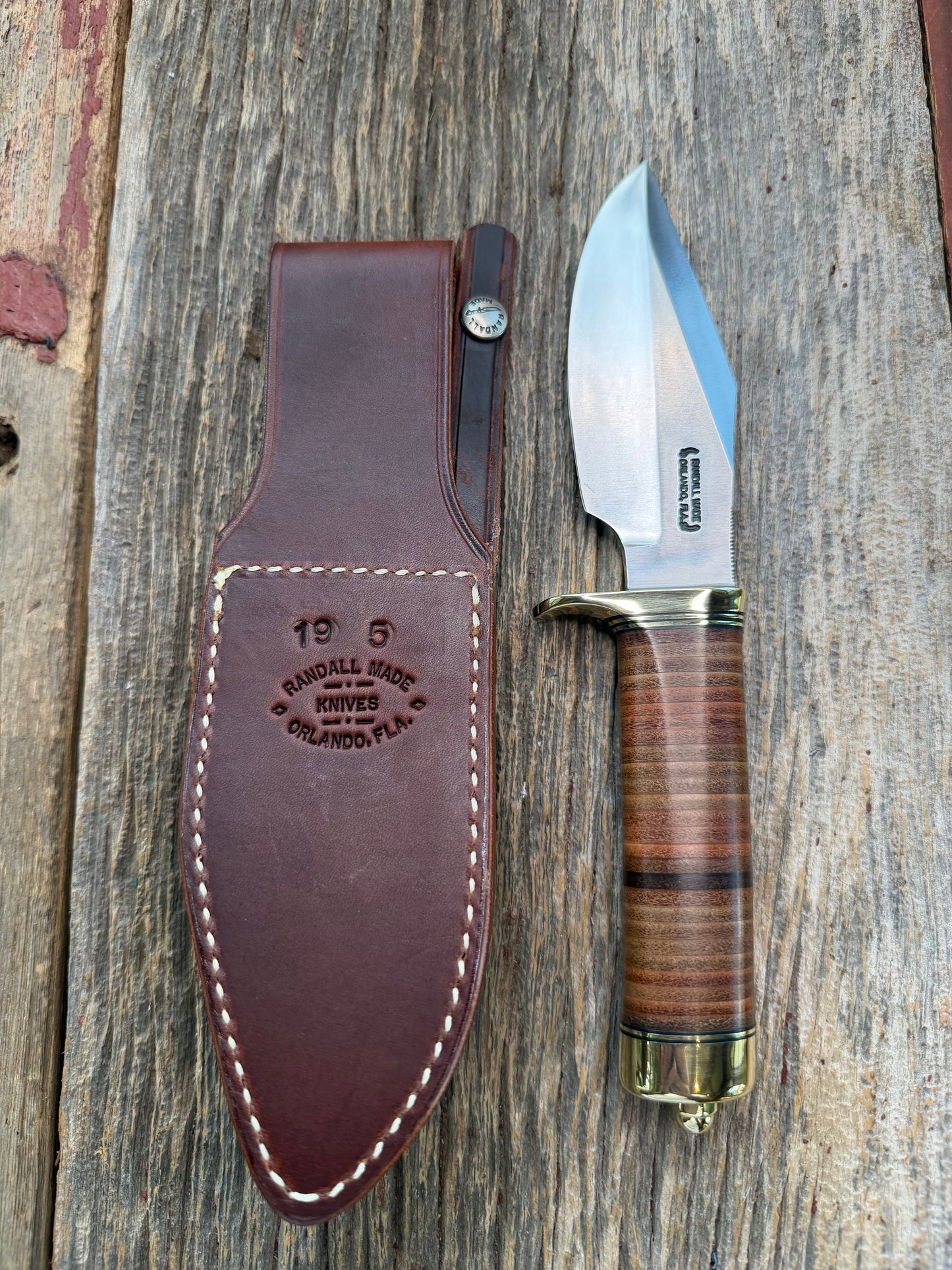 New Randall Model 19-5 Bushmaster with a Leather handle. Carbon blade, Brass single hilt. Brown leather sheath.