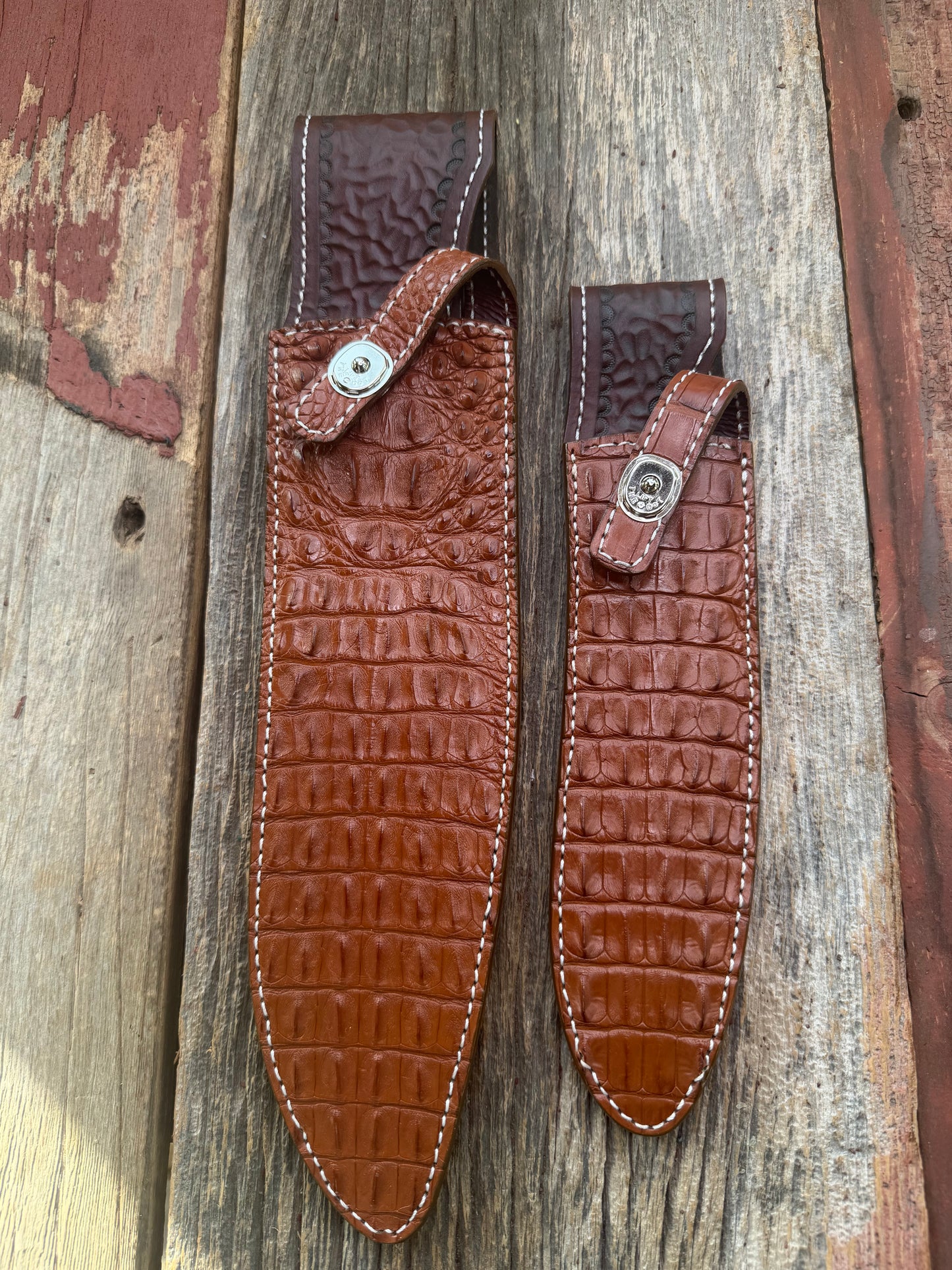 Pair of new Randall Model 12-11 Large and Small Sasquatch Sheaths in Exotic thick and textured Honey Crocodile skin ( skull portion) on brown leather from Treeman with a silver Canteen snap. Hand tooled belt loop. Killer sheath.