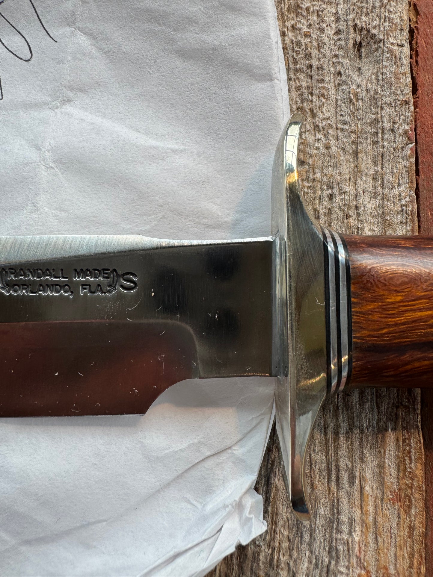 New in Paper Randall Model 1-7 Stainless steel blade, Nickel silver hilt and butt cap. Brown leather sheath. Burl wood handle.