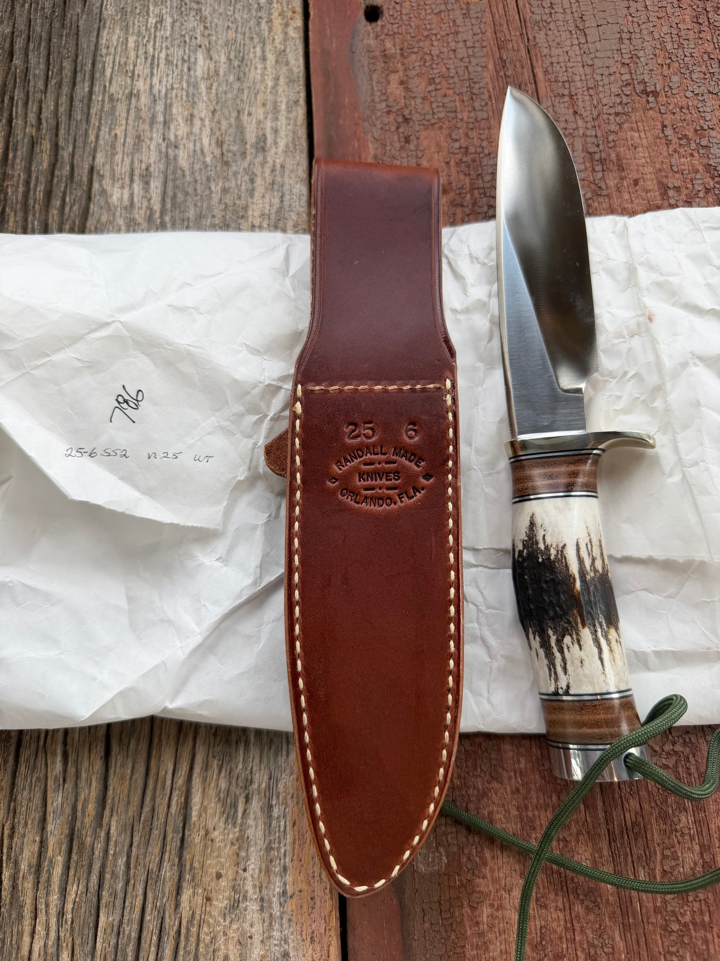 New in paper Randall Knife Model 25-6 Trapper in Stag Leather Handle Stainless Blade, nickel silver hilt , wrist thong.