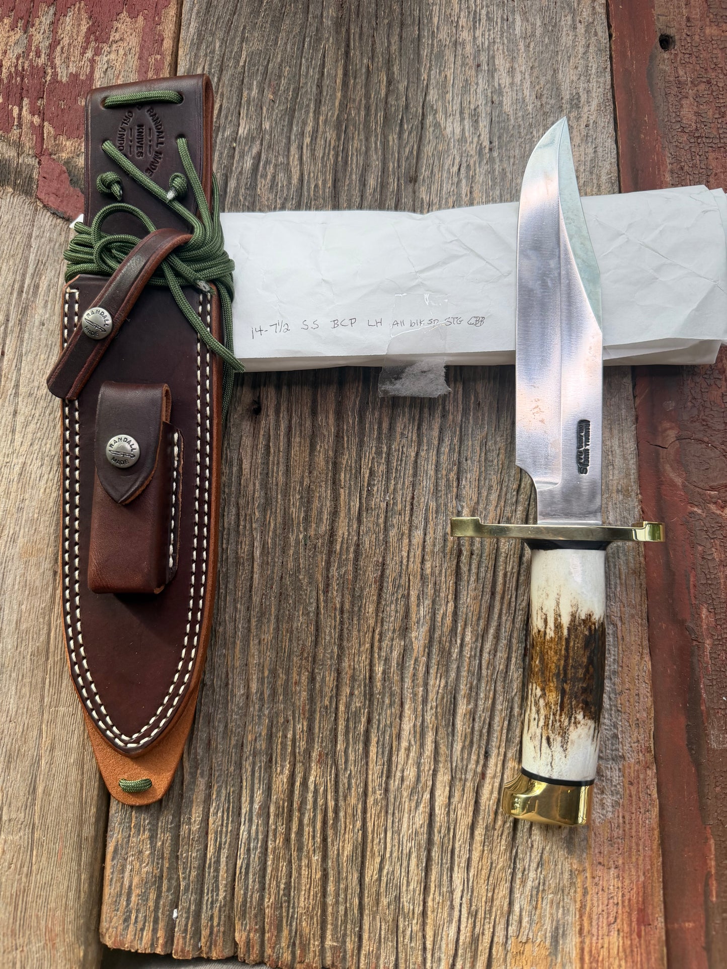 New in paper fresh from the Shop. Randall Knife Model 14-7.5 Big. Nice piece of Stag, Gorgeous Brass Lugged hilt and brass crows beak butt cap. Single black spacer. Stainless steel.