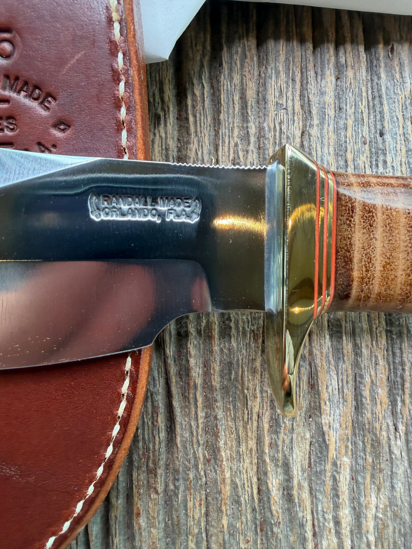 New in Paper Randall Model 19-5 Bushmaster with a Leather handle. Carbon blade, Brass single hilt. Brown leather sheath.