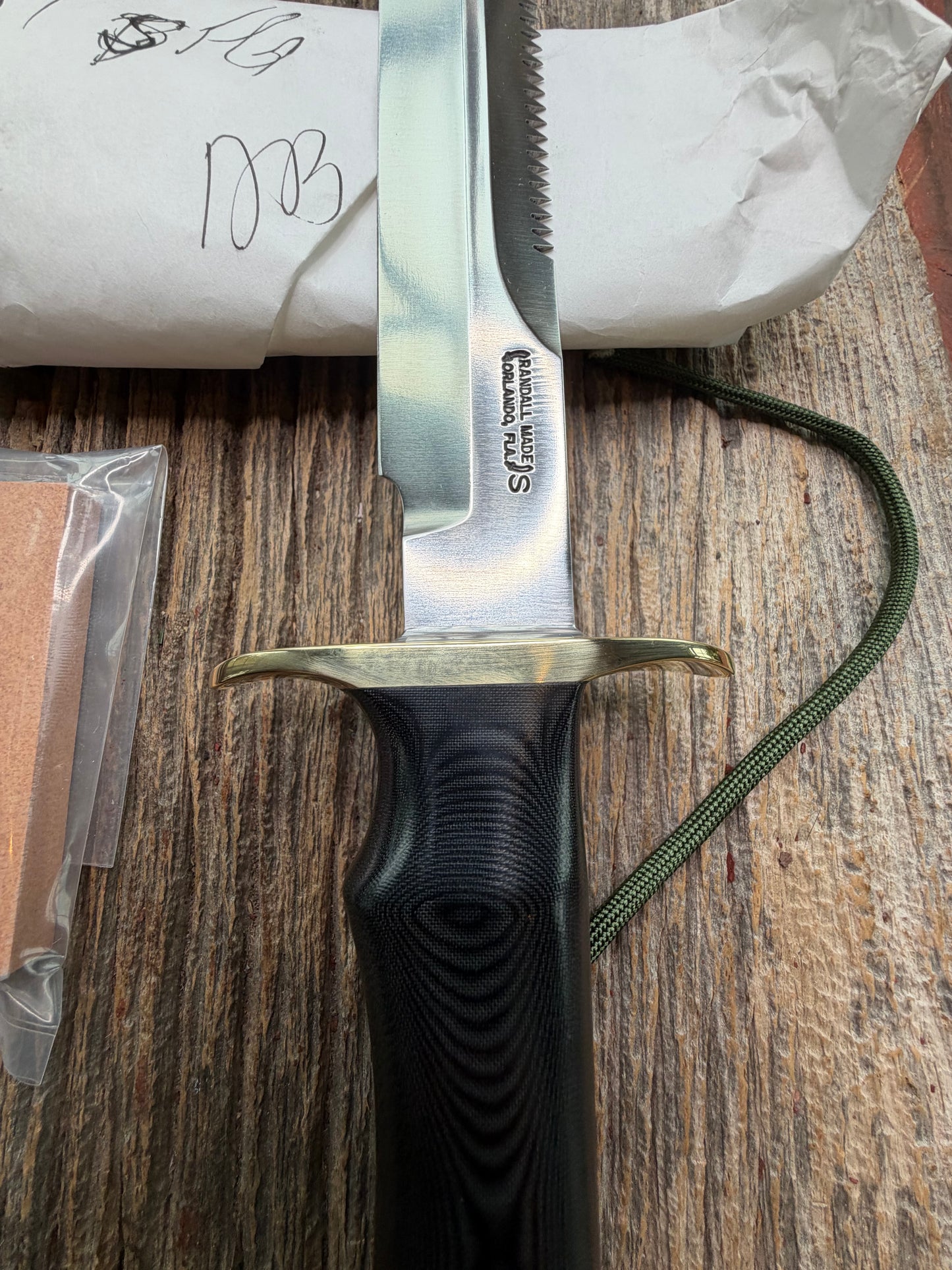 New in Paper Randall Model 16-7 Diver with a Black Micarta handle, Single finger grip , SS blade, Brass hilt, Sawteeth, Lanyard, Brown leather waxed sheath.