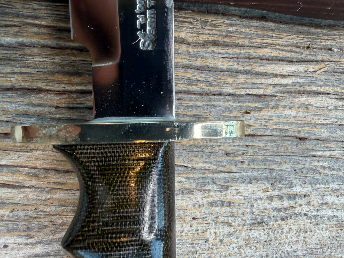 Nice Randall Model 16-7 with a glossy Brown Micarta handle. SS blade, double nickel silver hilt. Lanyard. Sawteeth, Brown waxed leather sheath.