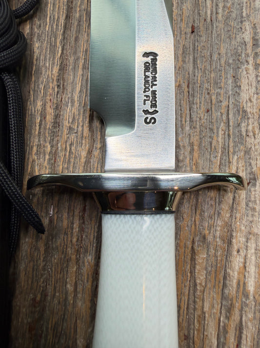 Randall Model 15 with a White Ivorite handle. Stainless steel blade, Nickel silver hilt and collar. Upgraded Black leather sheath.  Roundsd Aluminum butt cap.