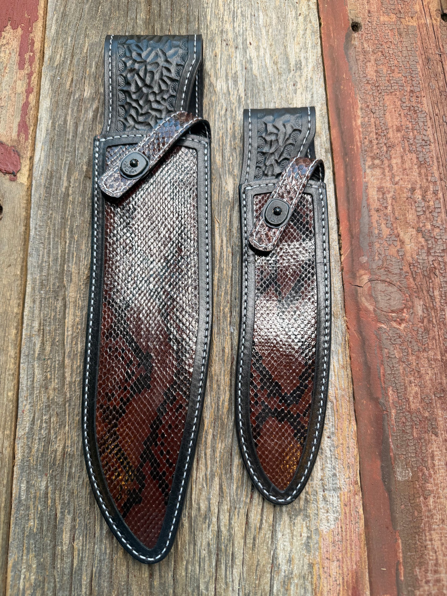 New pair of Randall Model 12-11 Large Sasquatch and 12-8 Small Sasquatch Sheath in Exotic Brown Python Snake on black leather from Treeman with a black Canteen snap. Hand tooled belt loop. Deviated white stitching. Killer sheath.