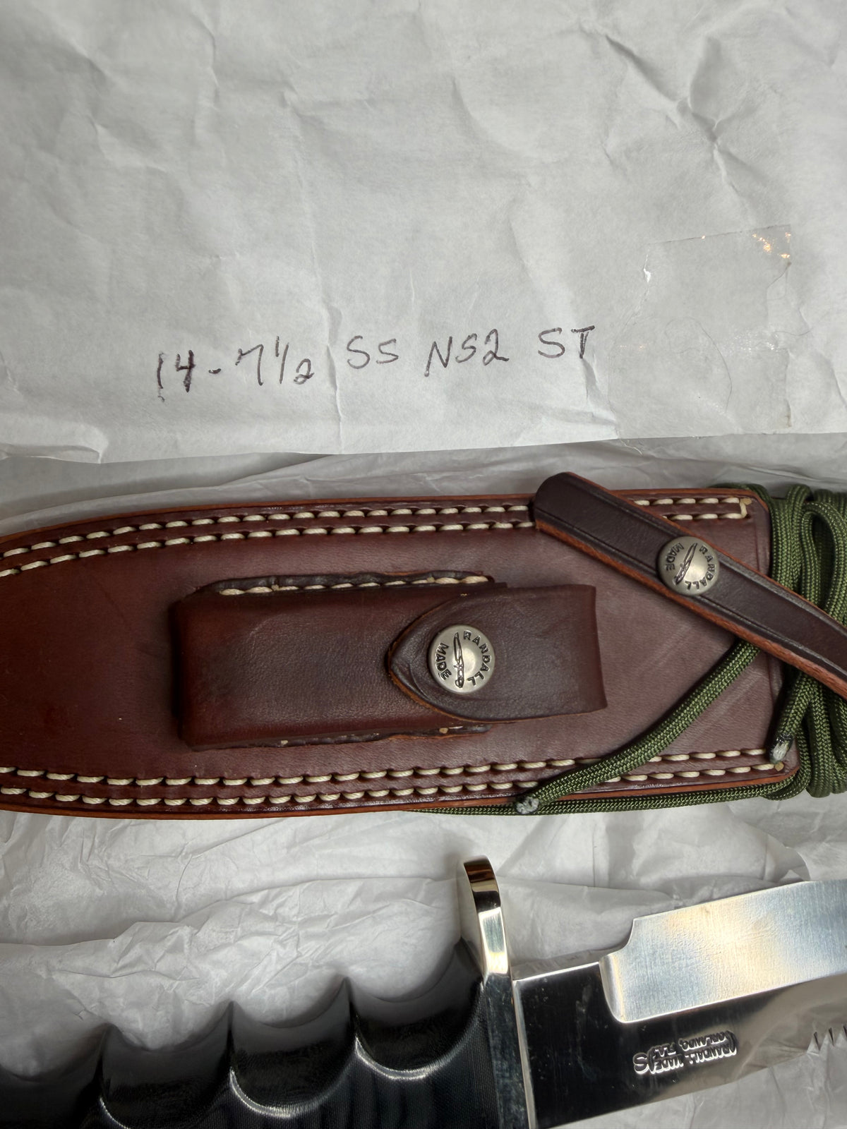 Randall Model 14-7.5 with a Black Micarta finger grooved handle. Stainless steel blade, Nickel double hilt brown leather sheath, Sawteeth, Lanyard.