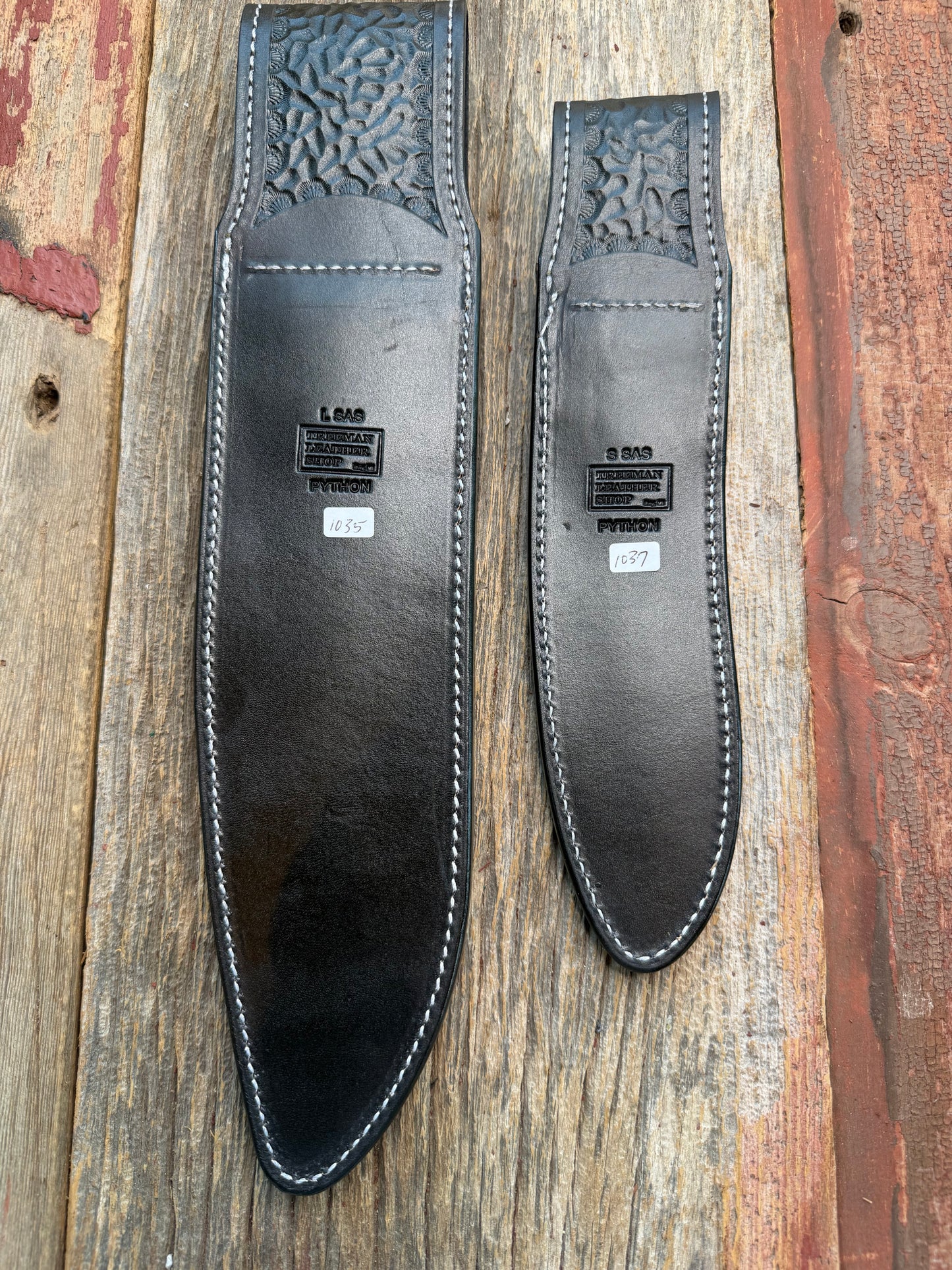 New pair of Randall Model 12-11 Large Sasquatch and 12-8 Small Sasquatch Sheath in Exotic Brown Python Snake on black leather from Treeman with a black Canteen snap. Hand tooled belt loop. Deviated white stitching. Killer sheath.