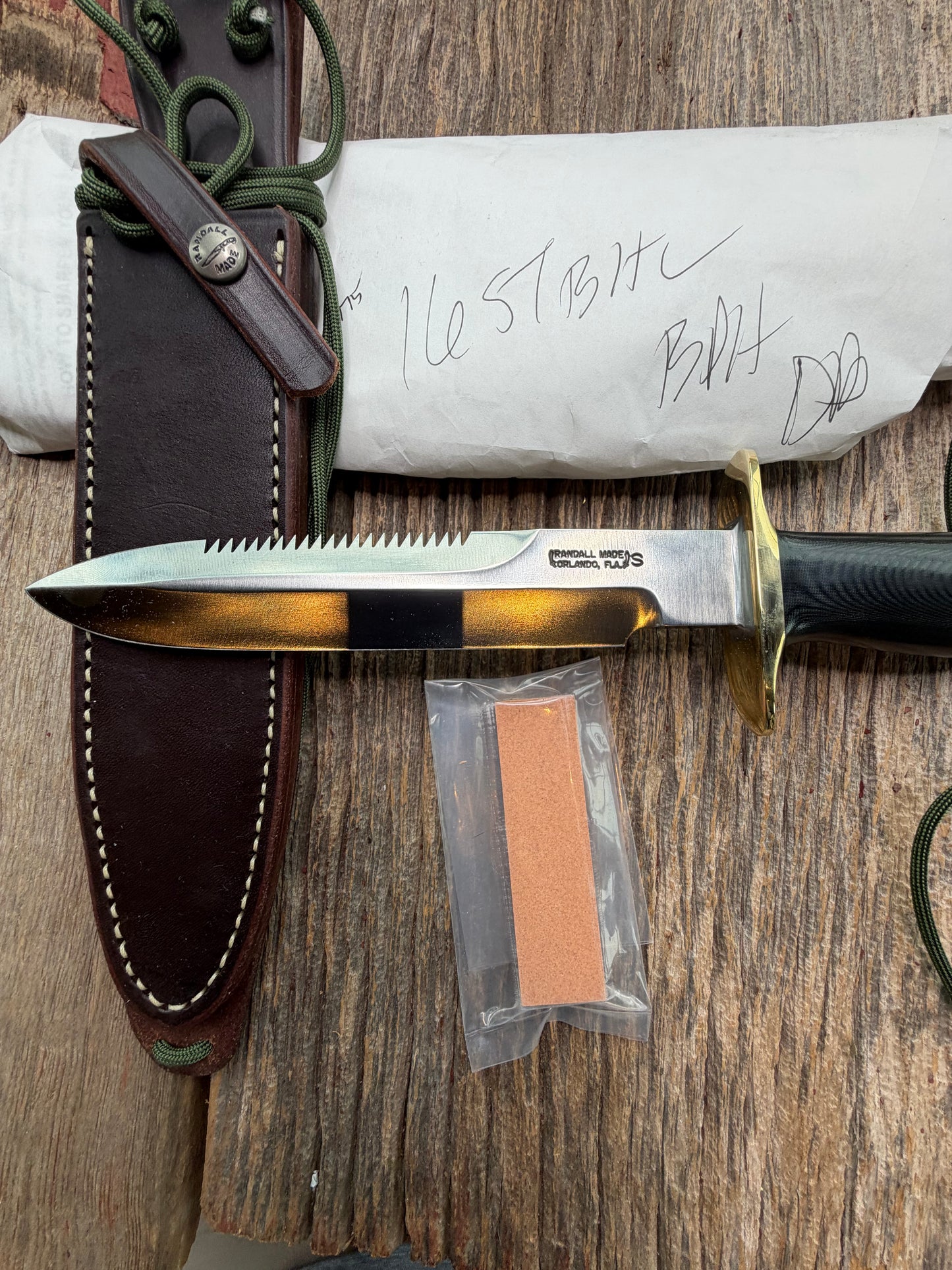 New in Paper Randall Model 16-7 Diver with a Black Micarta handle. SS blade, Brass hilt, Sawteeth, Lanyard, Brown leather waxed sheath.