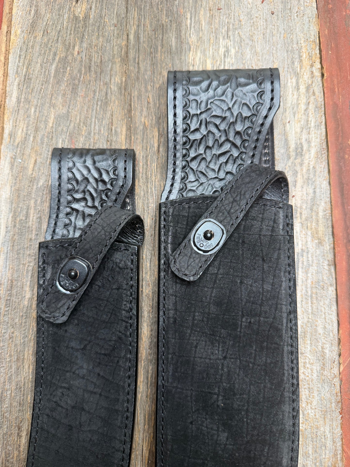 Randall Model 12-11 Large Sasquatch and Model 12-8 Small Sasquatch in Black Hippo, forward curved hilt, black Canteen Snap, full brass stamping and stitching.