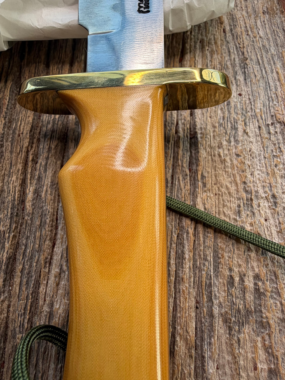 Randall Model 14-7.5 with a Yellow Micarta single finger handle. Carbon steel blade, brass double hilt, brown leather sheath, Lanyard.