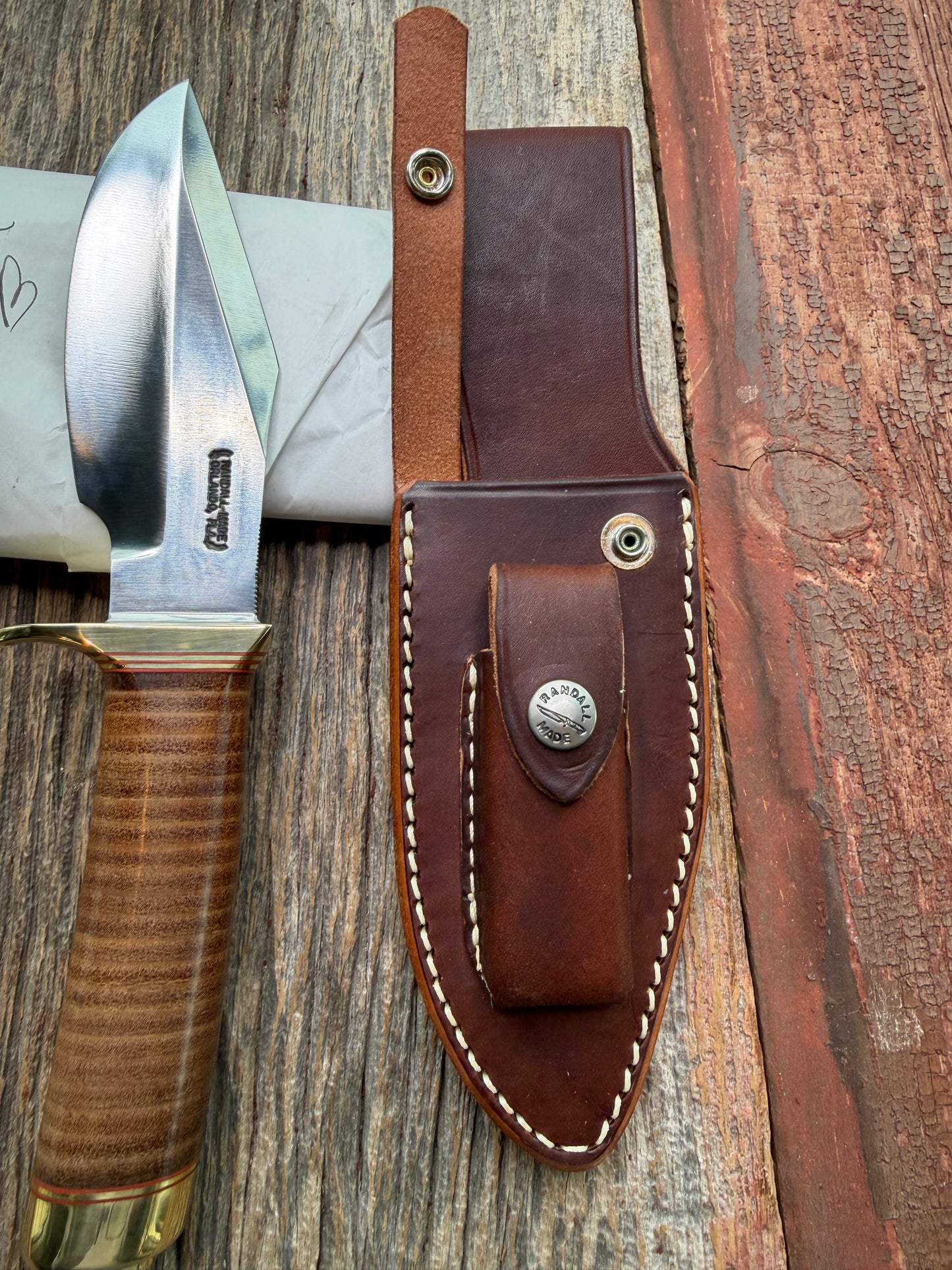 New in Paper Randall Model 19-5 Bushmaster with a Leather handle. Carbon blade, Brass single hilt. Brown leather sheath.