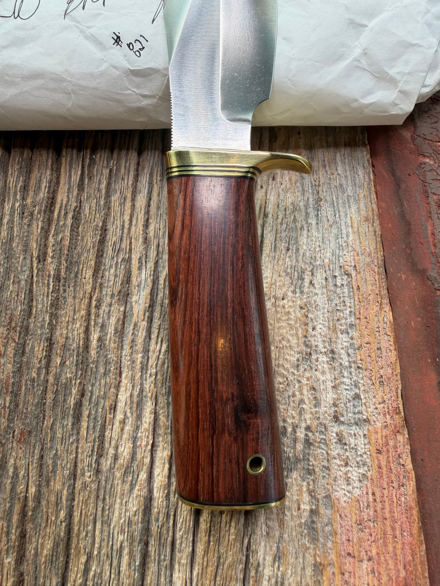New in Paper Randall Model 19-5 with a really nice grainy piece of Ironwood. brass single Hilt , Stainless steel, Lanyard and Brass plate.