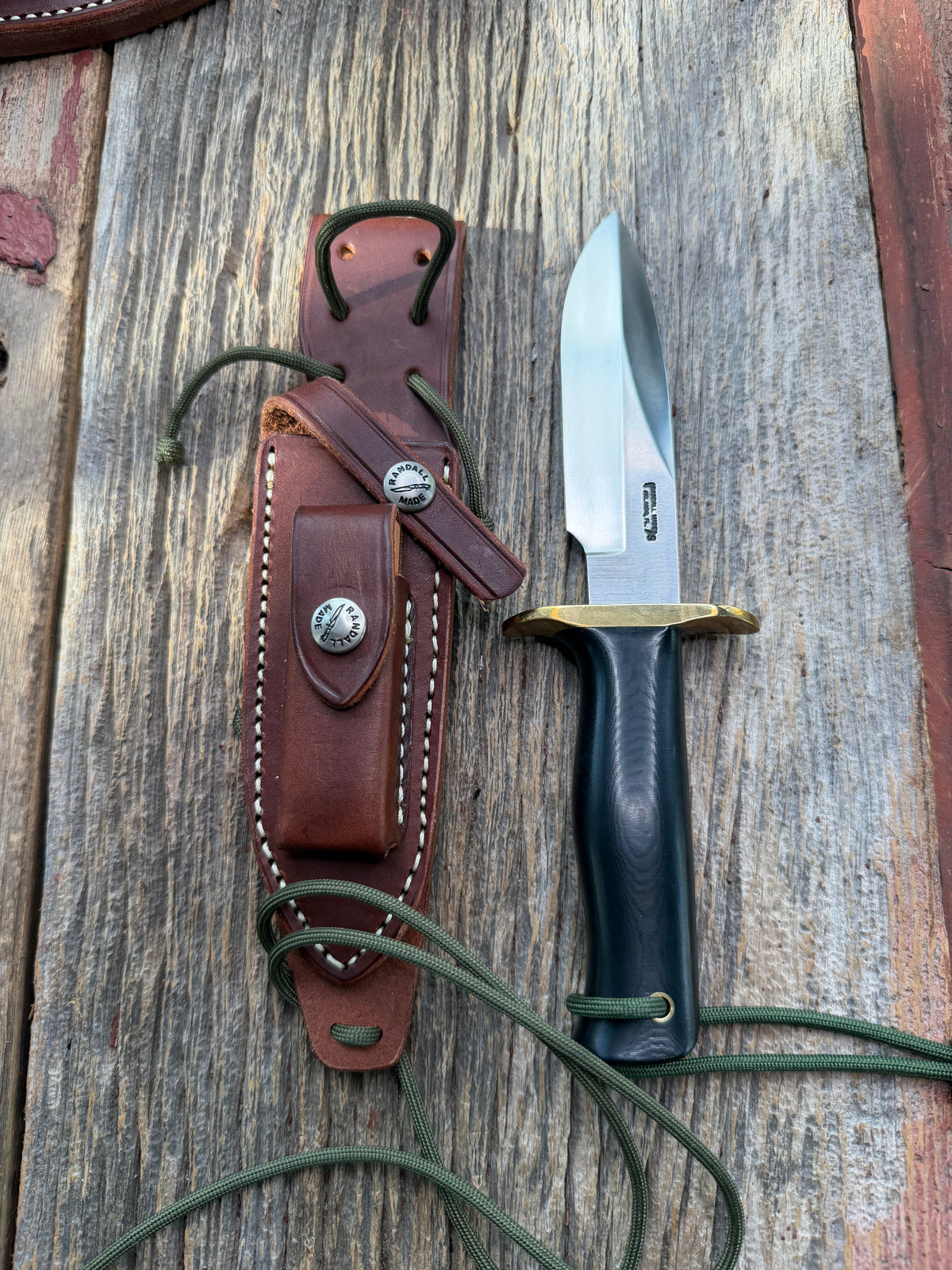 Nice Randall Model Combat Companion in Black Micarta. SS blade, brass hilt. Lanyard and paracord, Brown leather sheath.
