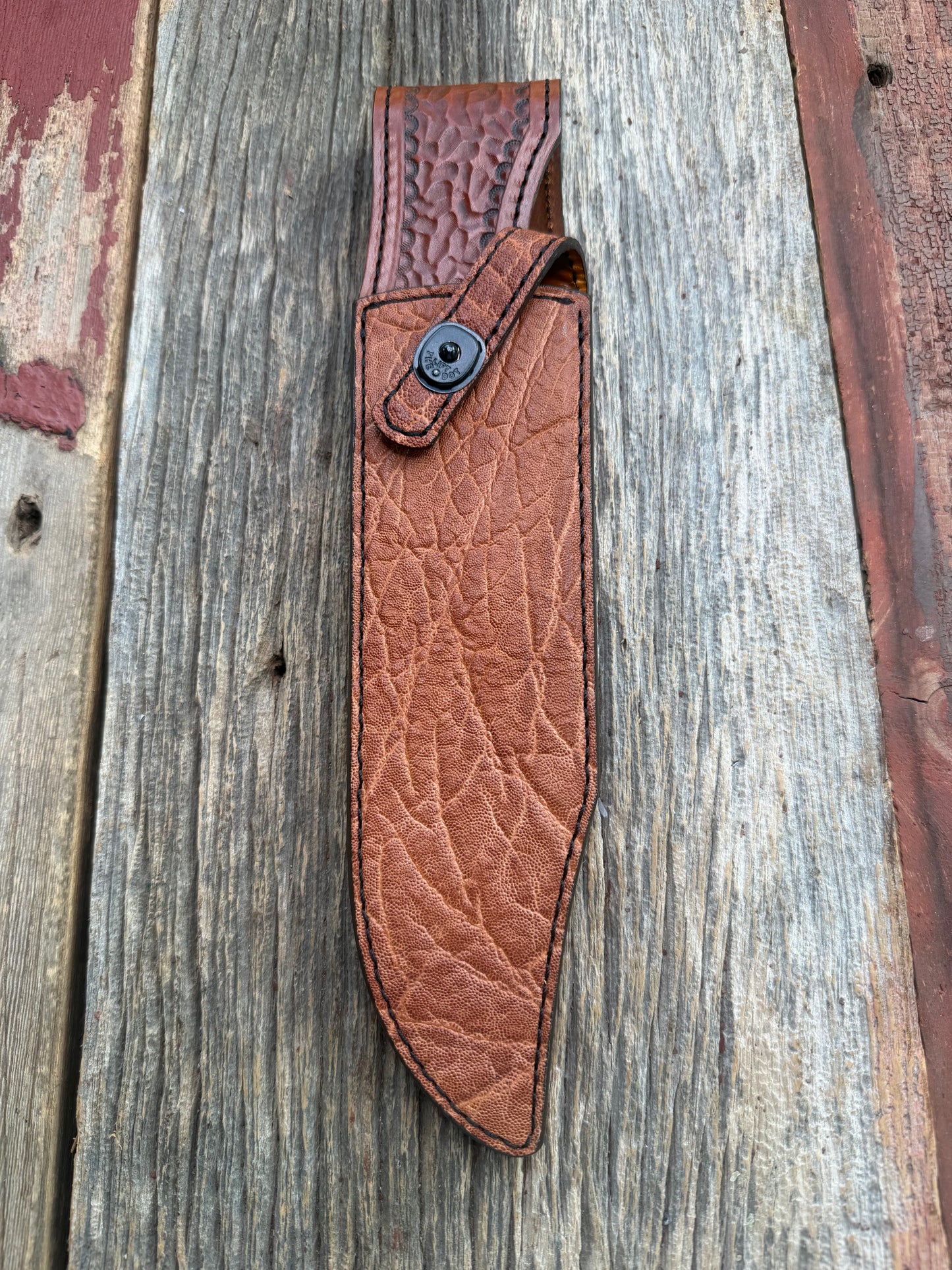 New Randall Model 12-9/14 Sheath in Exotic thick and textured Rust colored Elephant hide on brown leather from Treeman with a black Canteen snap. Hand tooled belt loop. Killer sheath.