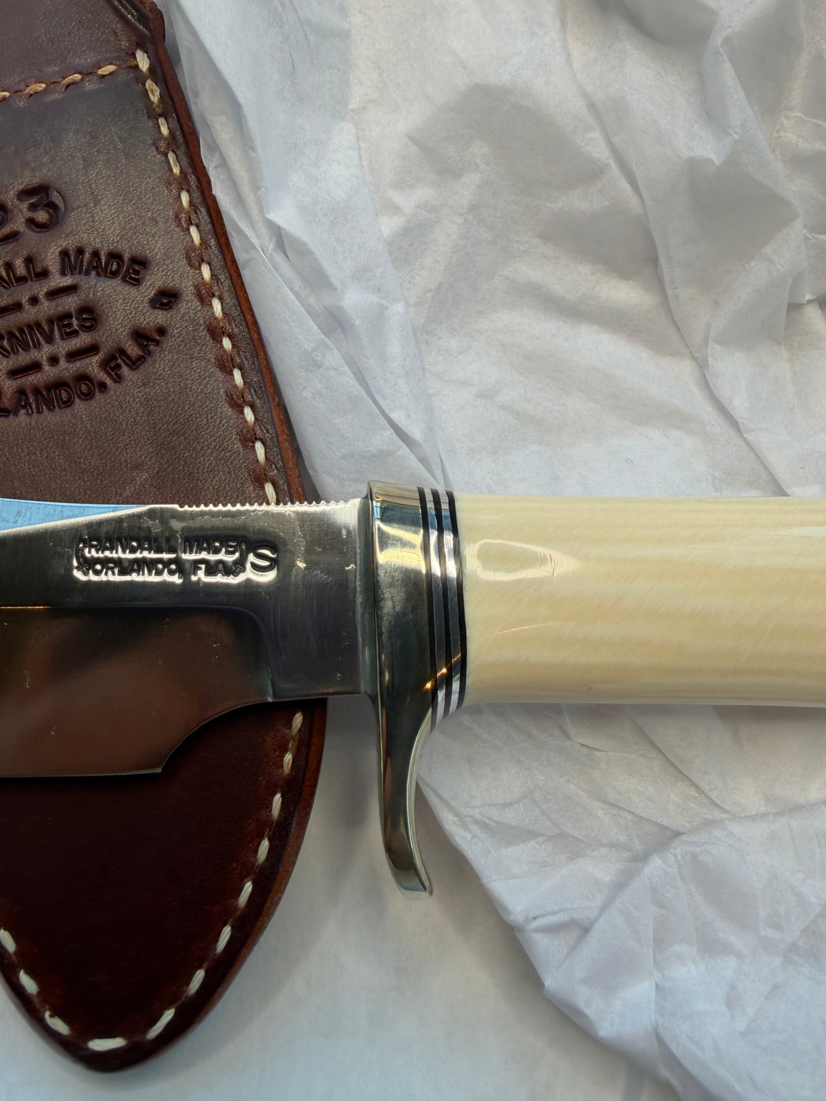 New in paper Randall Model 23 Game Master in dealer supplied Resin, Stainless steel blade, Nickel silver hilt and butt cap, Black and Aluminum spacers and Brown leather sheath.