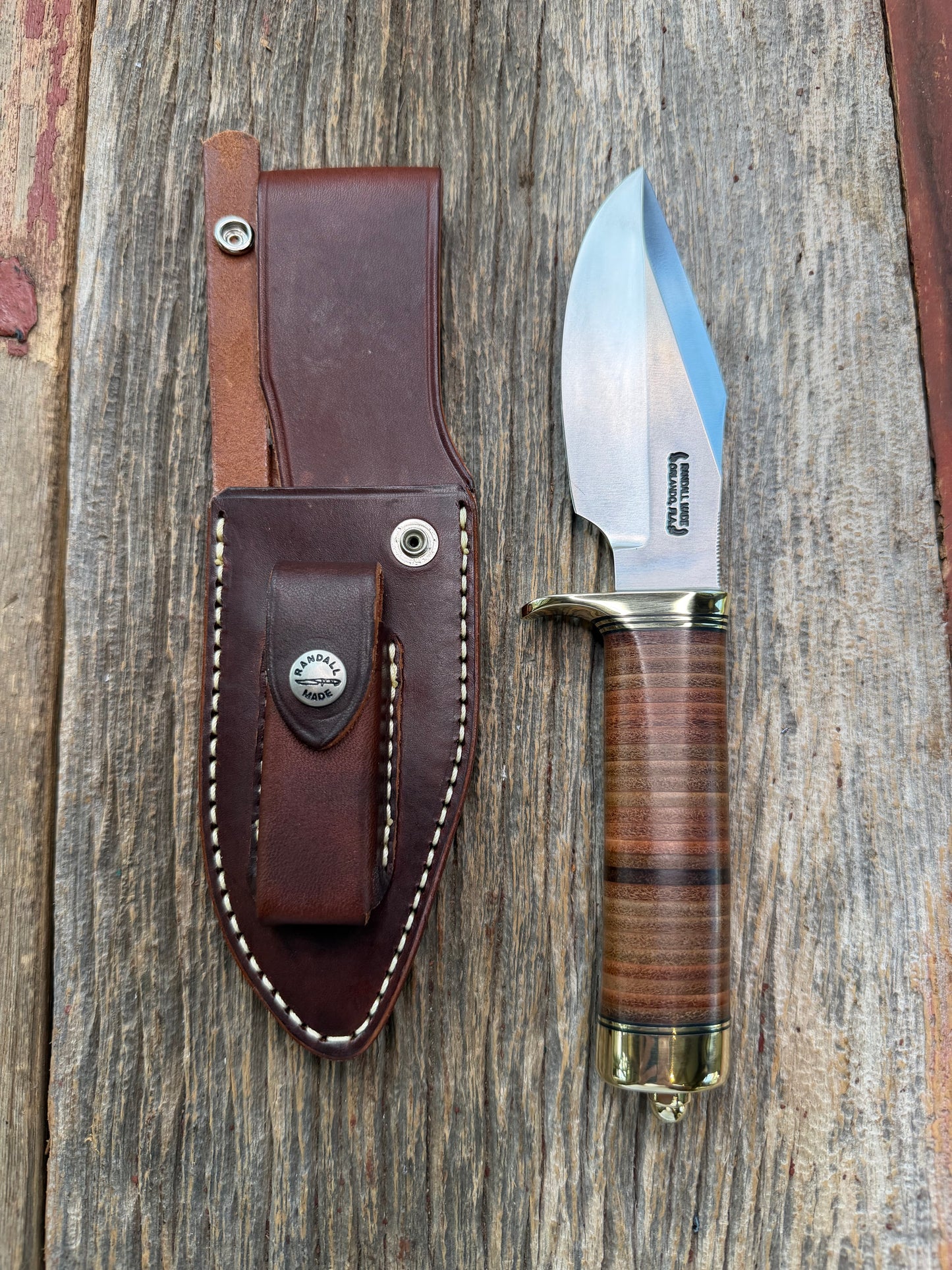 New Randall Model 19-5 Bushmaster with a Leather handle. Carbon blade, Brass single hilt. Brown leather sheath.