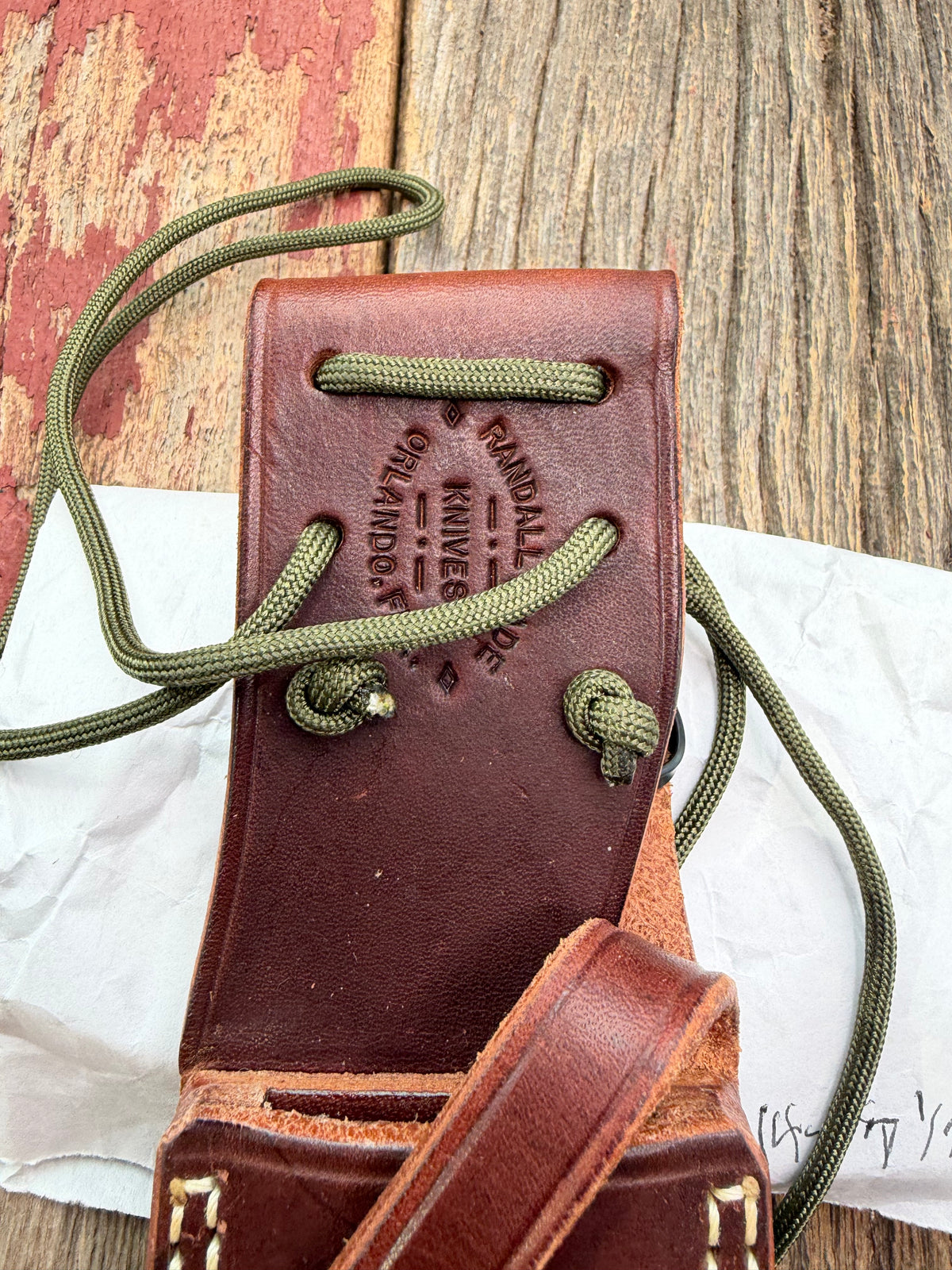 Randall Model 14-7.5 with a Black Micarta finger grooved handle. Stainless steel blade, brass double hilt brown leather sheath, Lanyard.