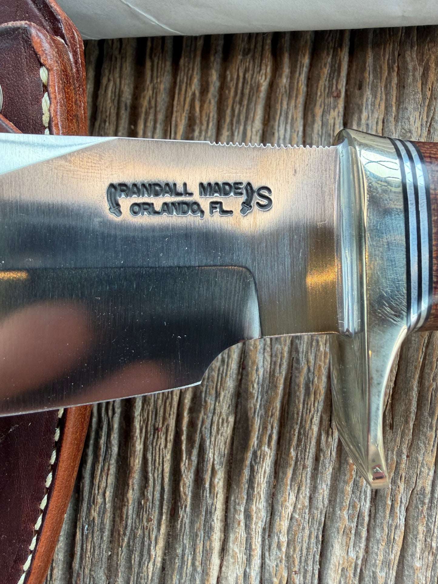 New in Paper Randall Model 19-5 Bushmaster with an Brown Micarta handle. SS blade, Nickel silver single hilt. Lanyard. Brown leather sheath.