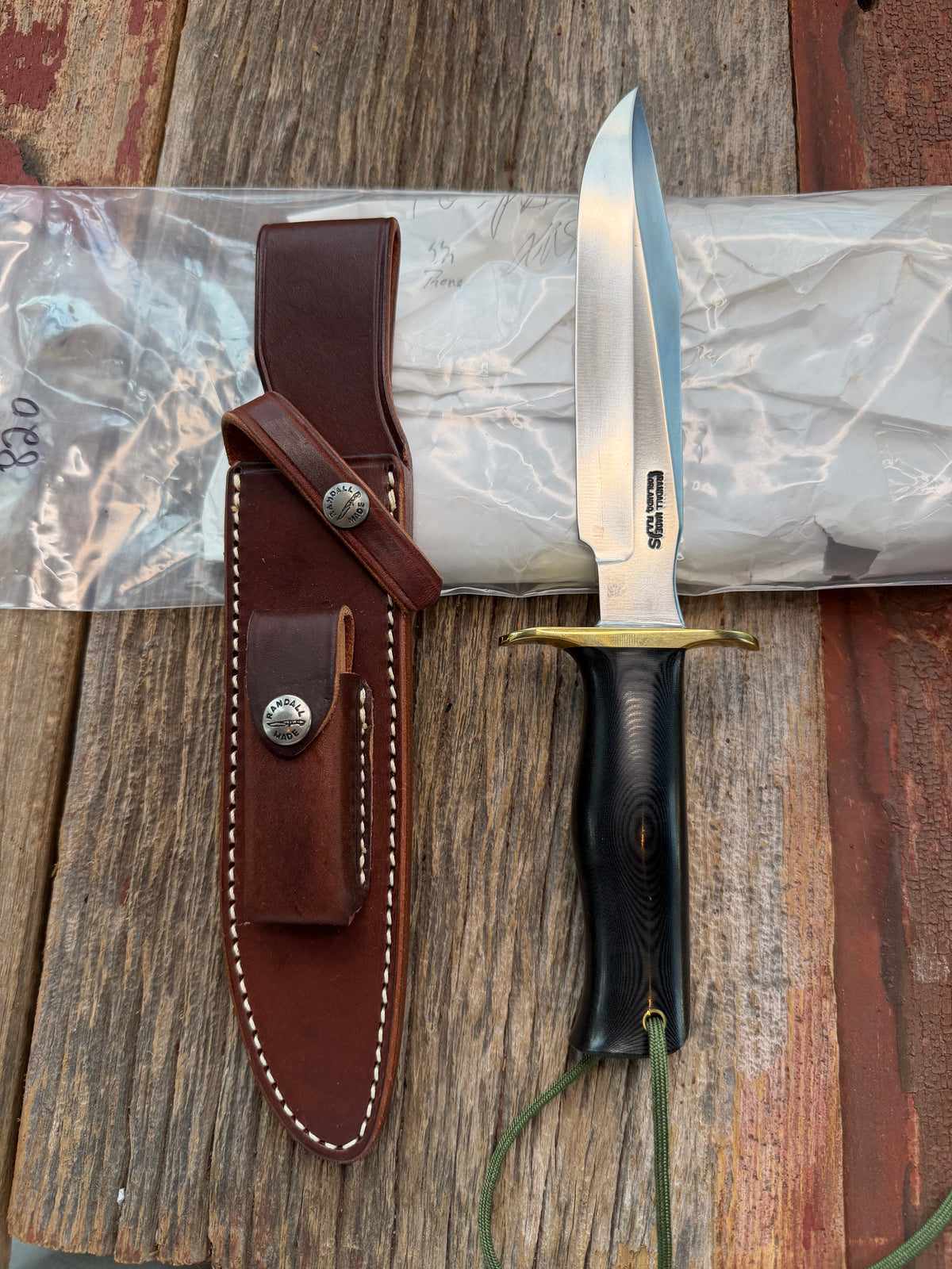 New in paper Randall Model 16 SP#1 Special fighter with a Black Micarta handle. SS blade, brass hilt. Lanyard. Brown leather sheath.