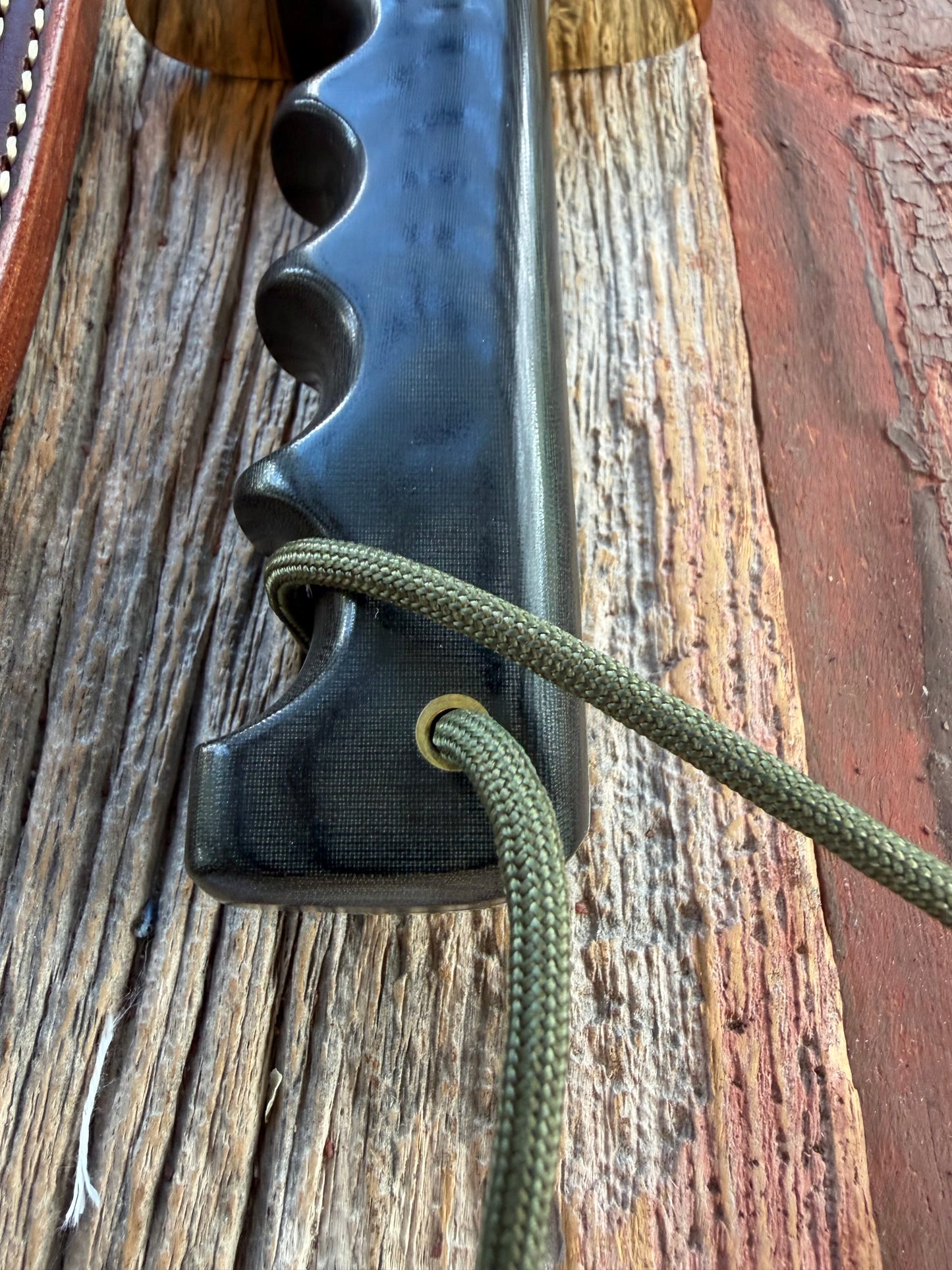 Randall Model 14-7.5 with a Black Micarta finger grooved handle. Stainless steel blade, Brass double hilt brown leather sheath.