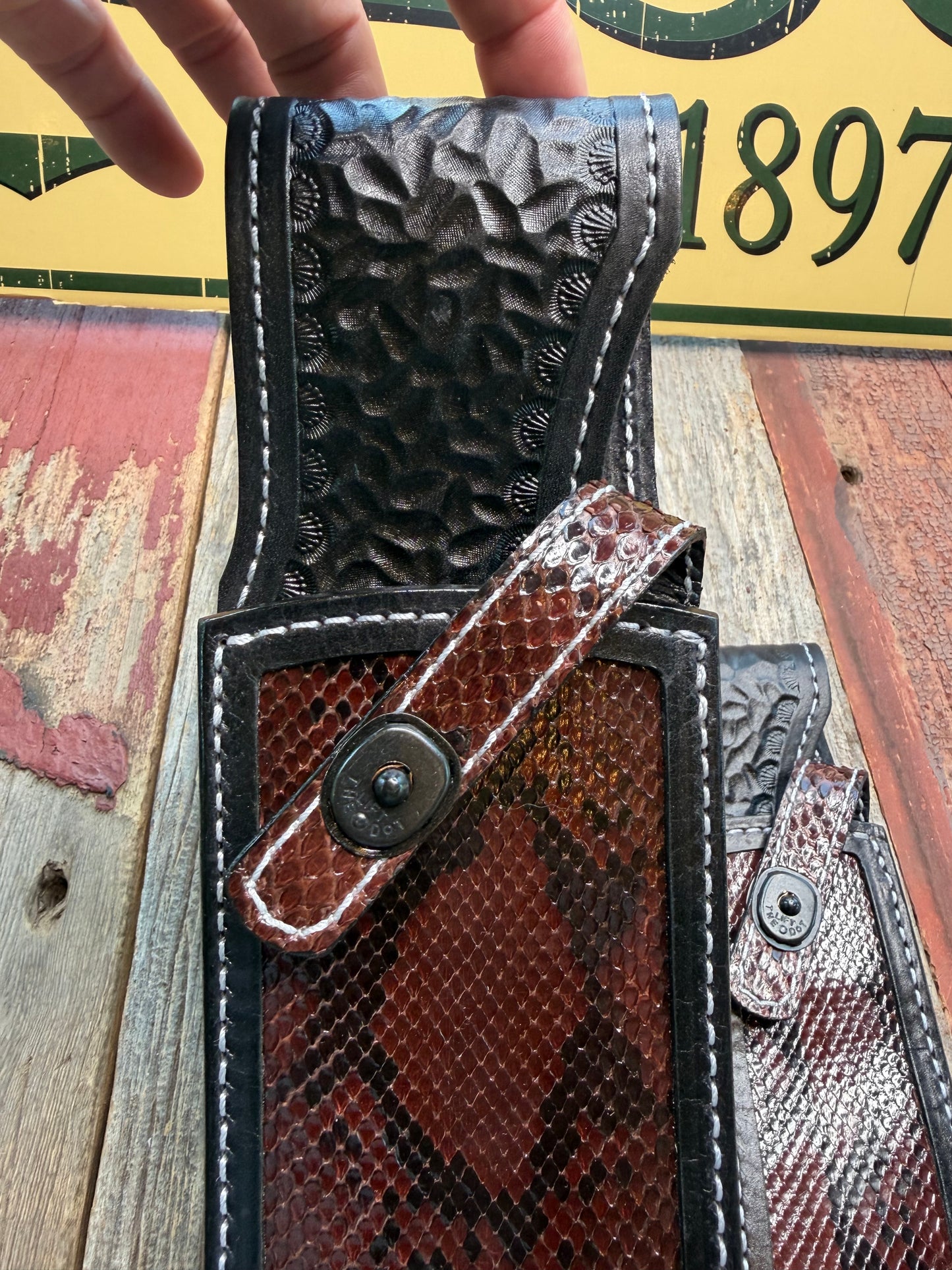New pair of Randall Model 12-11 Large Sasquatch and 12-8 Small Sasquatch Sheath in Exotic Brown Python Snake on black leather from Treeman with a black Canteen snap. Hand tooled belt loop. Deviated white stitching. Killer sheath.