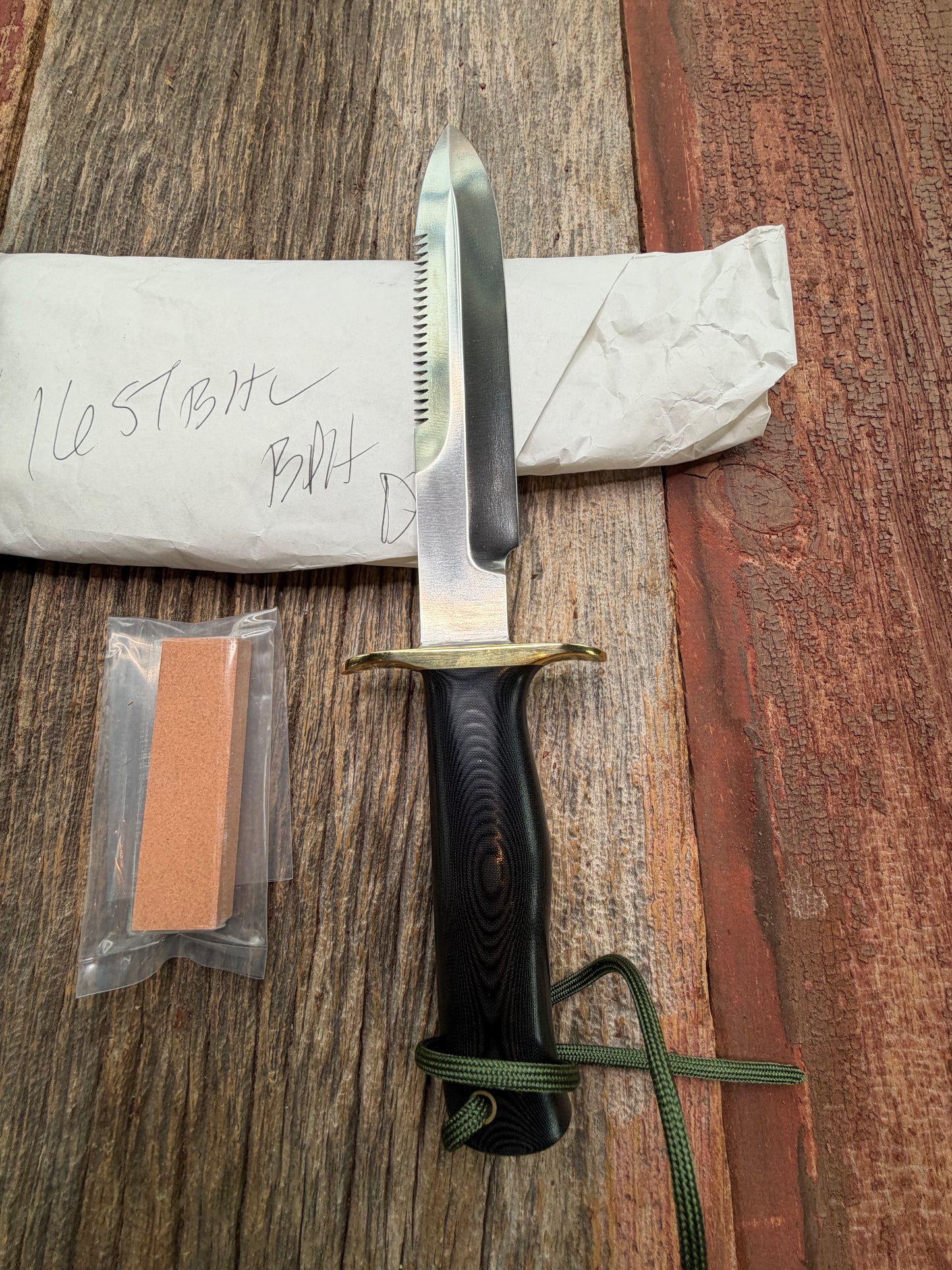 New in Paper Randall Model 16-7 Diver with a Black Micarta handle. SS blade, Brass hilt, Sawteeth, Lanyard, Brown leather waxed sheath.
