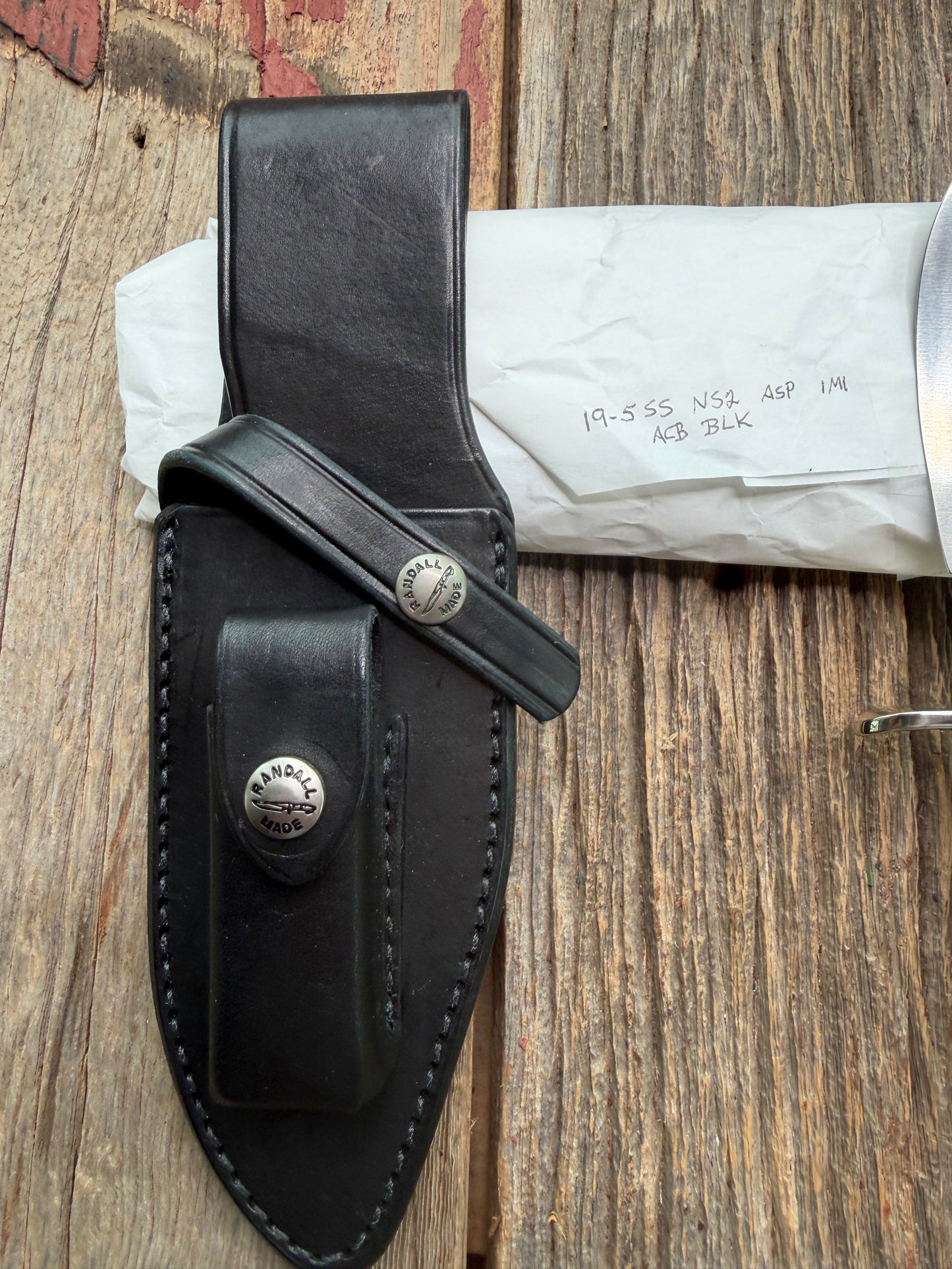 New in Paper Randall Model 19-5 Bushmaster with a White Ivorite handle. Stainless steel blade, Nickel silver hilt. Upgraded Black leather sheath. Crows Beak Aluminum handle.