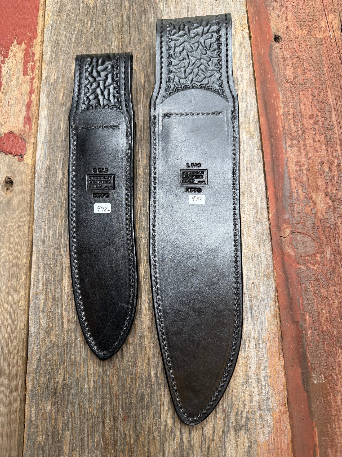 Randall Model 12-11 Large Sasquatch and Model 12-8 Small Sasquatch in Black Hippo, forward curved hilt, black Canteen Snap, full brass stamping and stitching.