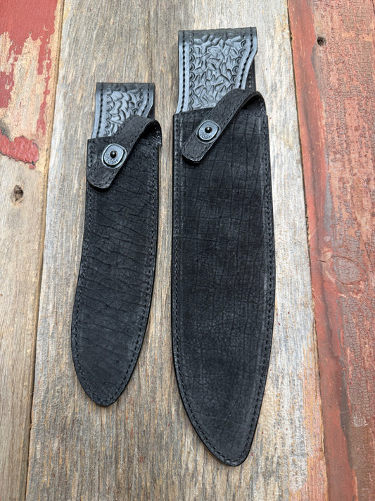Randall Model 12-11 Large Sasquatch and Model 12-8 Small Sasquatch in Black Hippo, forward curved hilt, black Canteen Snap, full brass stamping and stitching.