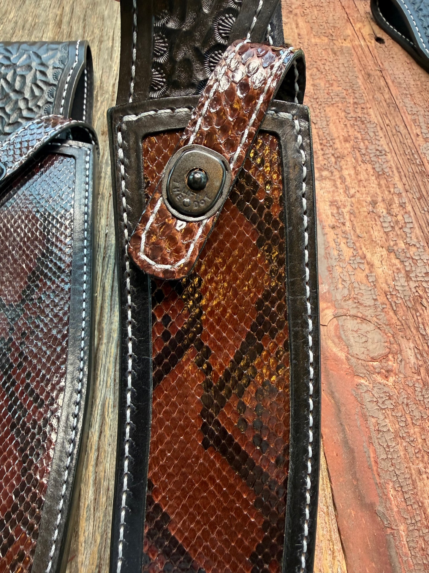 New pair of Randall Model 12-11 Large Sasquatch and 12-8 Small Sasquatch Sheath in Exotic Brown Python Snake on black leather from Treeman with a black Canteen snap. Hand tooled belt loop. Deviated white stitching. Killer sheath.