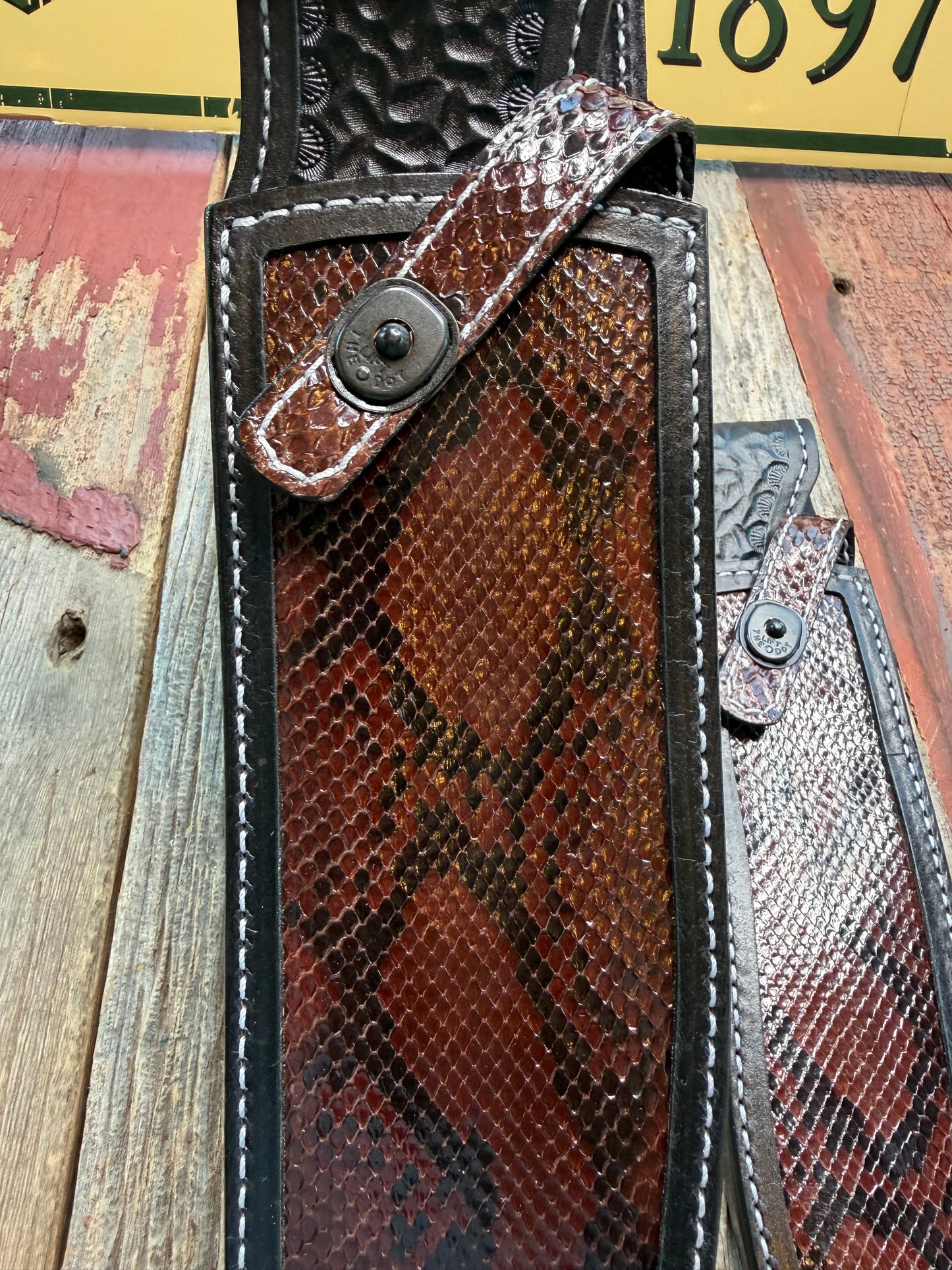 New pair of Randall Model 12-11 Large Sasquatch and 12-8 Small Sasquatch Sheath in Exotic Brown Python Snake on black leather from Treeman with a black Canteen snap. Hand tooled belt loop. Deviated white stitching. Killer sheath.