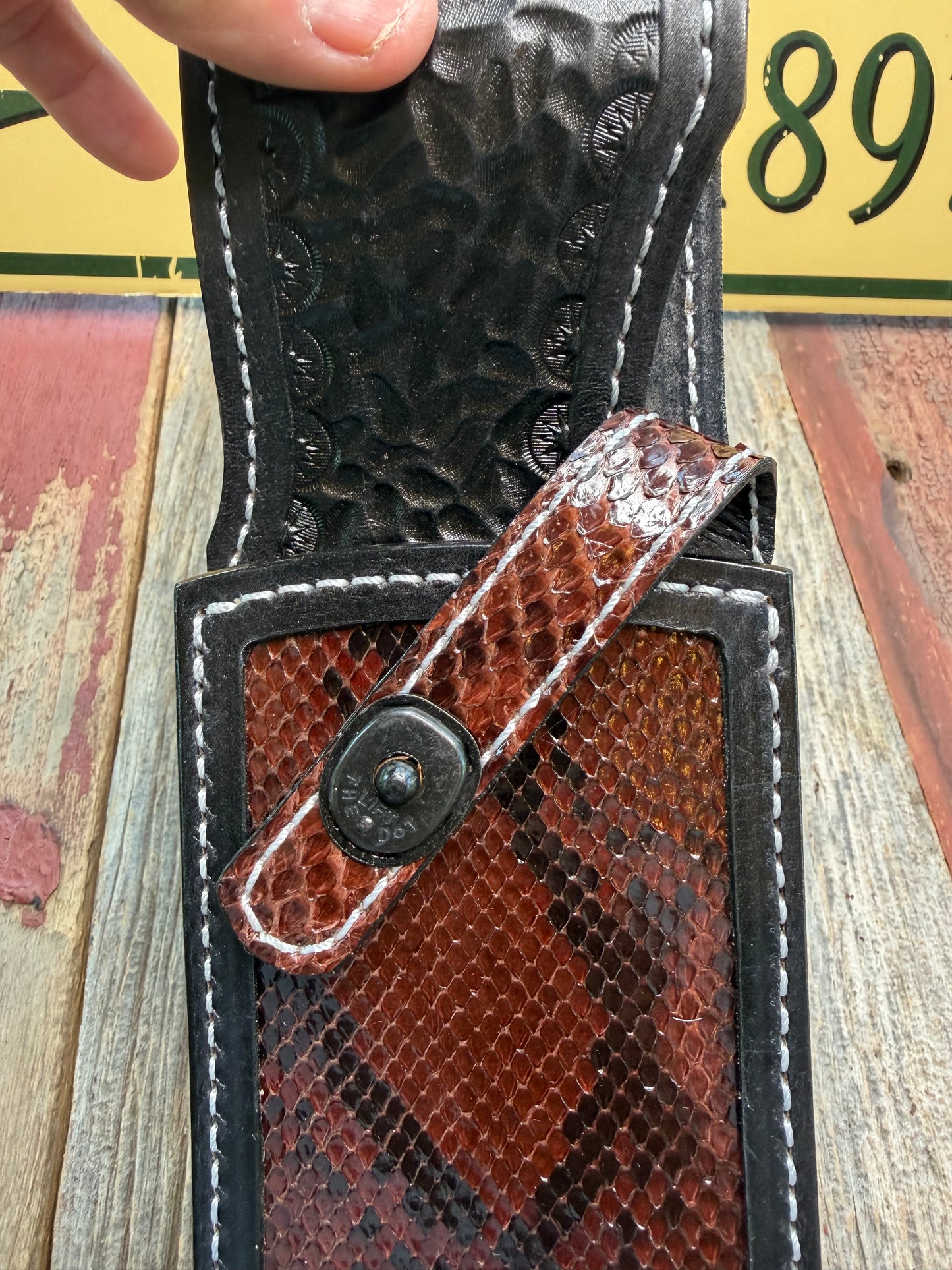 New Randall Model 12-11 Large Sasquatch Sheath in Exotic Brown Python Snake on black leather from Treeman with a black Canteen snap. Hand tooled belt loop. Deviated white stitching. Killer sheath.