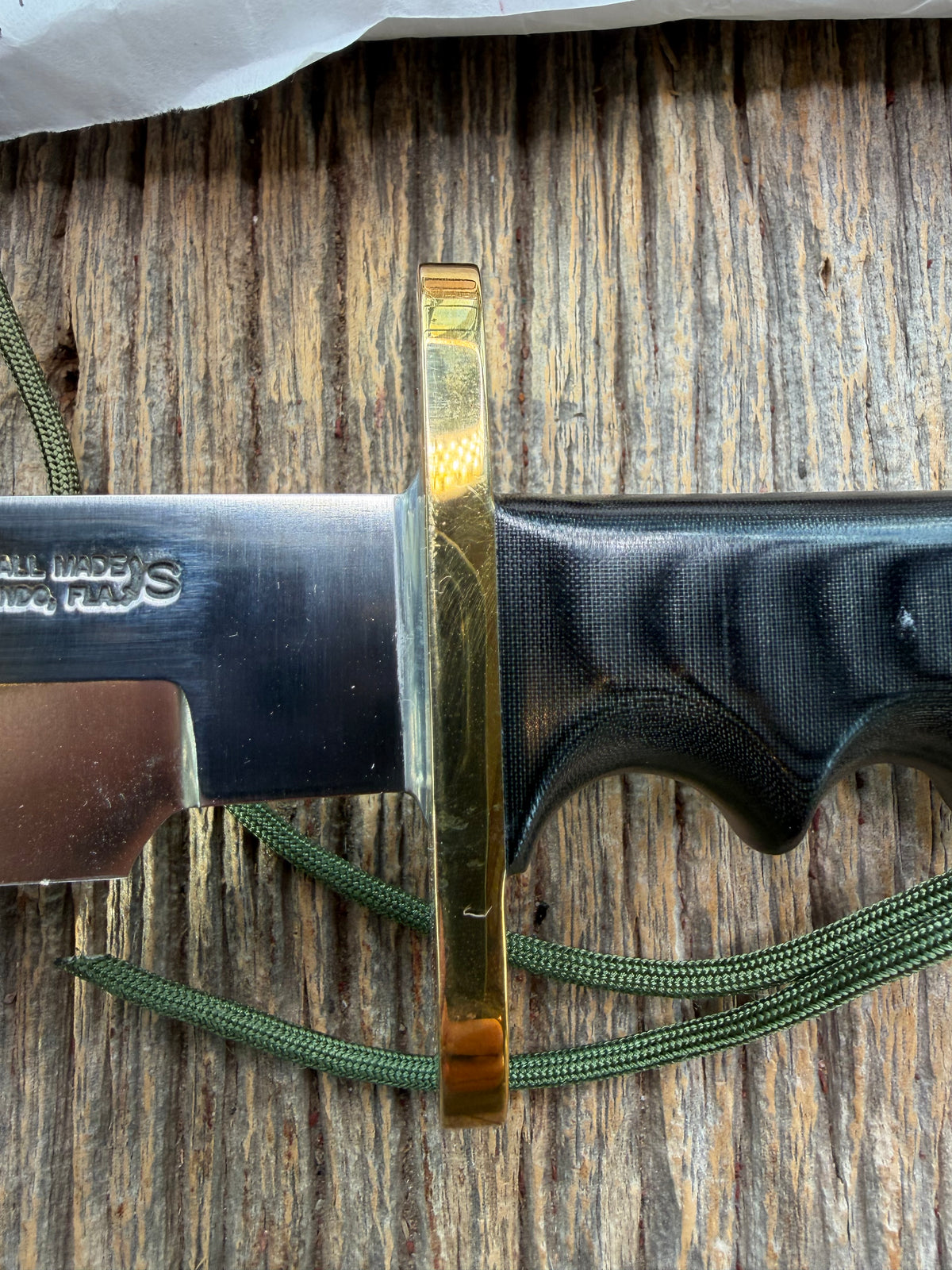 Randall Model 14-7.5 with a Black Micarta finger grooved handle. Stainless steel blade, brass double hilt brown leather sheath, Lanyard.