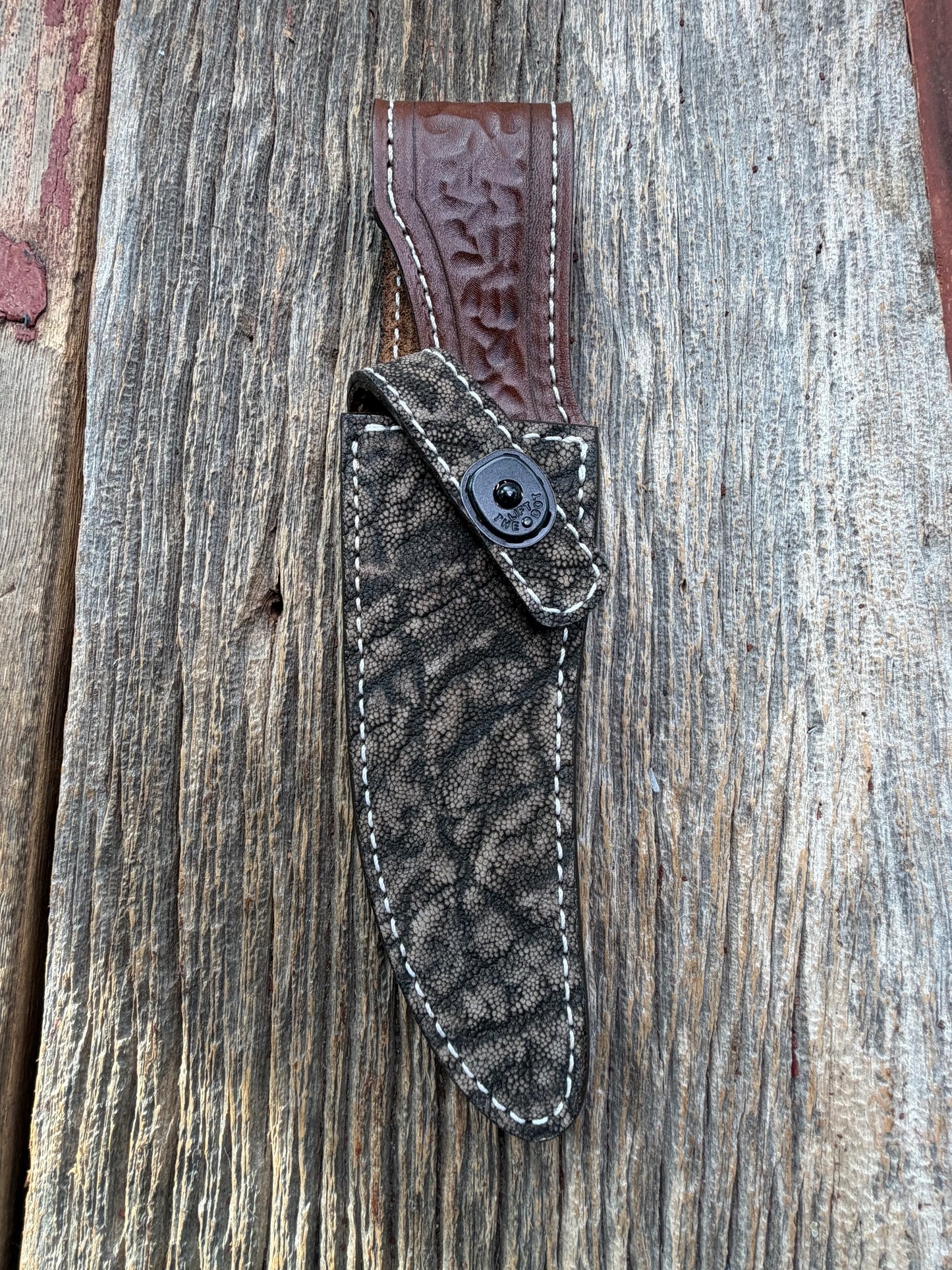 New Randall Model 27 Sheath in Exotic thick and textured Black and Grey Elephant Ear  on brown leather from Treeman with a black Canteen snap. Hand tooled belt loop. Killer sheath.