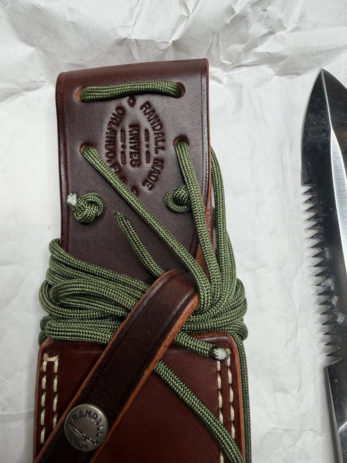 Randall Model 14-7.5 with a Black Micarta finger grooved handle. Stainless steel blade, Nickel double hilt brown leather sheath, Sawteeth, Lanyard.