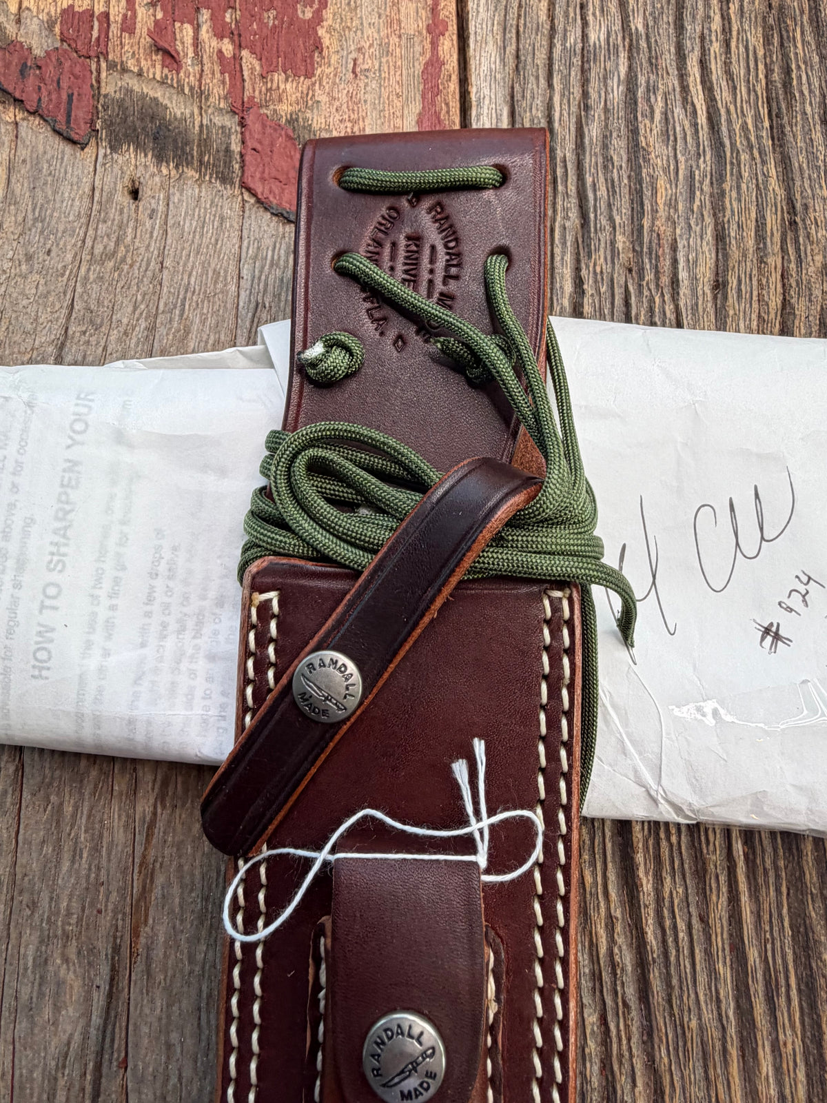 Randall Model 14-7.5 with a Yellow Micarta single finger handle. Carbon steel blade, brass double hilt, brown leather sheath, Lanyard.