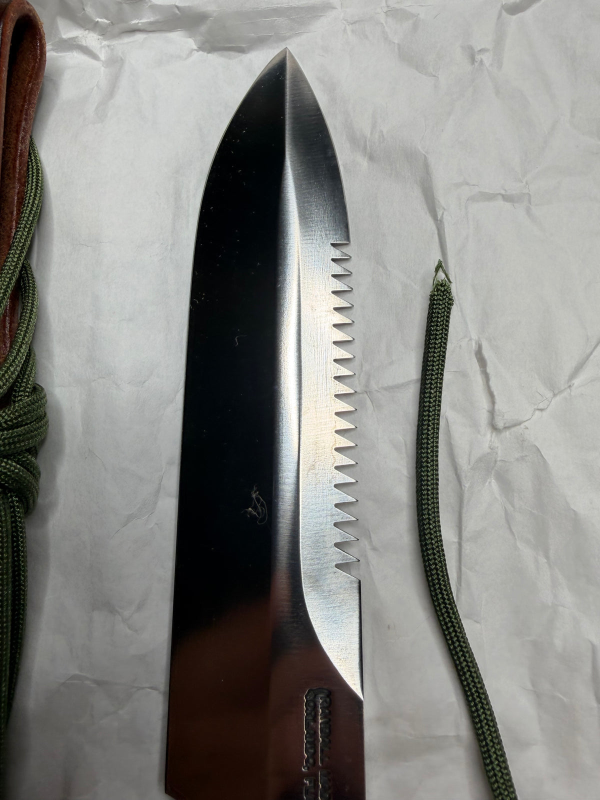 Randall Model 14-7.5 with a Black Micarta finger grooved handle. Stainless steel blade, Nickel double hilt brown leather sheath, Sawteeth, Lanyard.