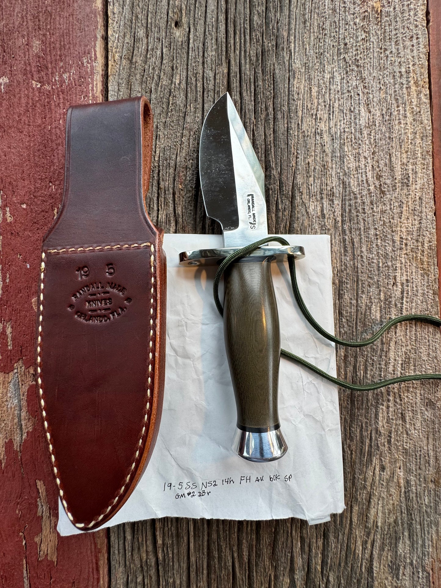 New in Paper Randall Model 19-5 Bushmaster with an Green Micarta handle. SS blade, Nickel silver single hilt. Lanyard. Brown leather sheath.