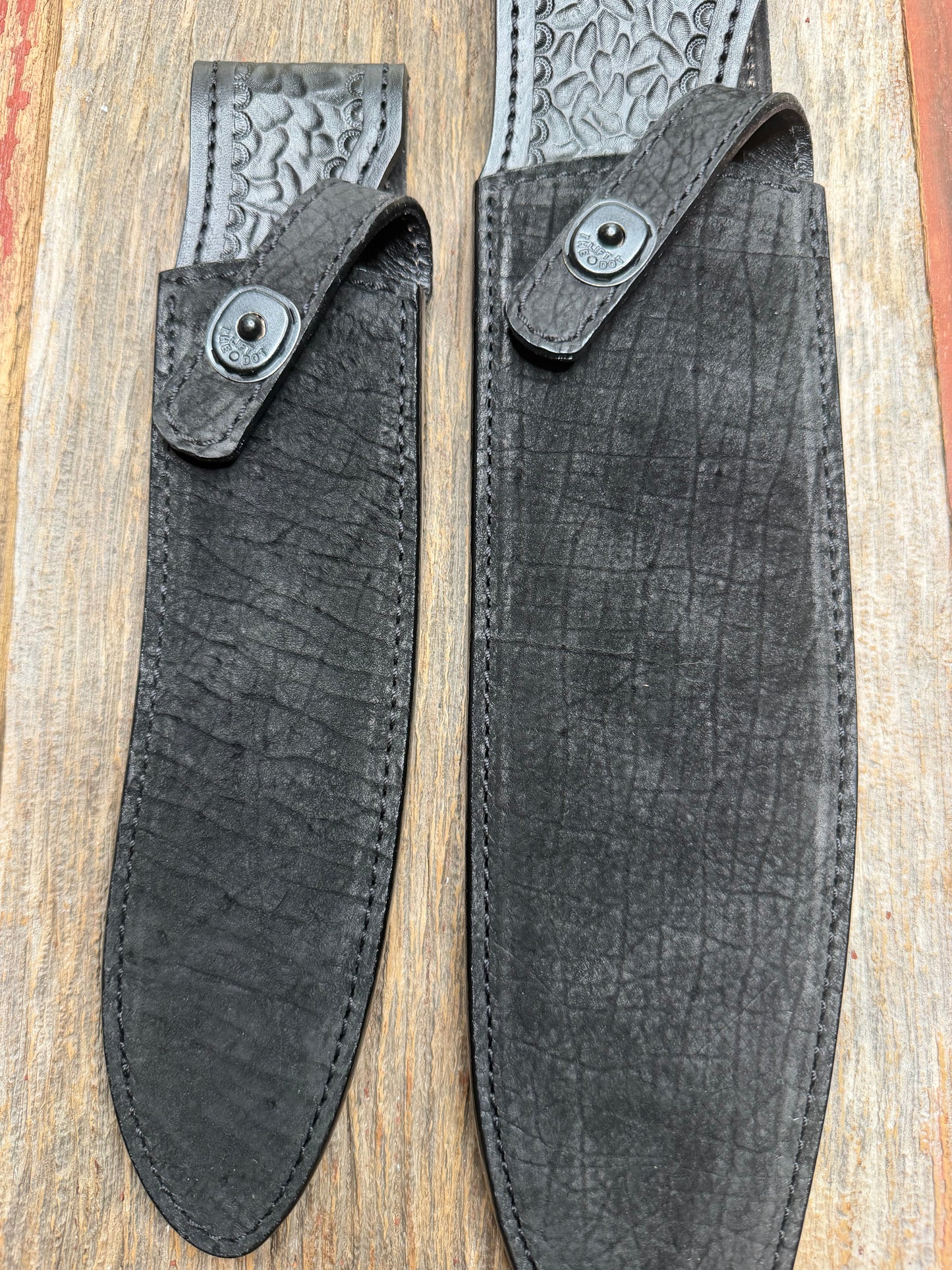 Randall Model 12-11 Large Sasquatch and Model 12-8 Small Sasquatch in Black Hippo, forward curved hilt, black Canteen Snap, full brass stamping and stitching.